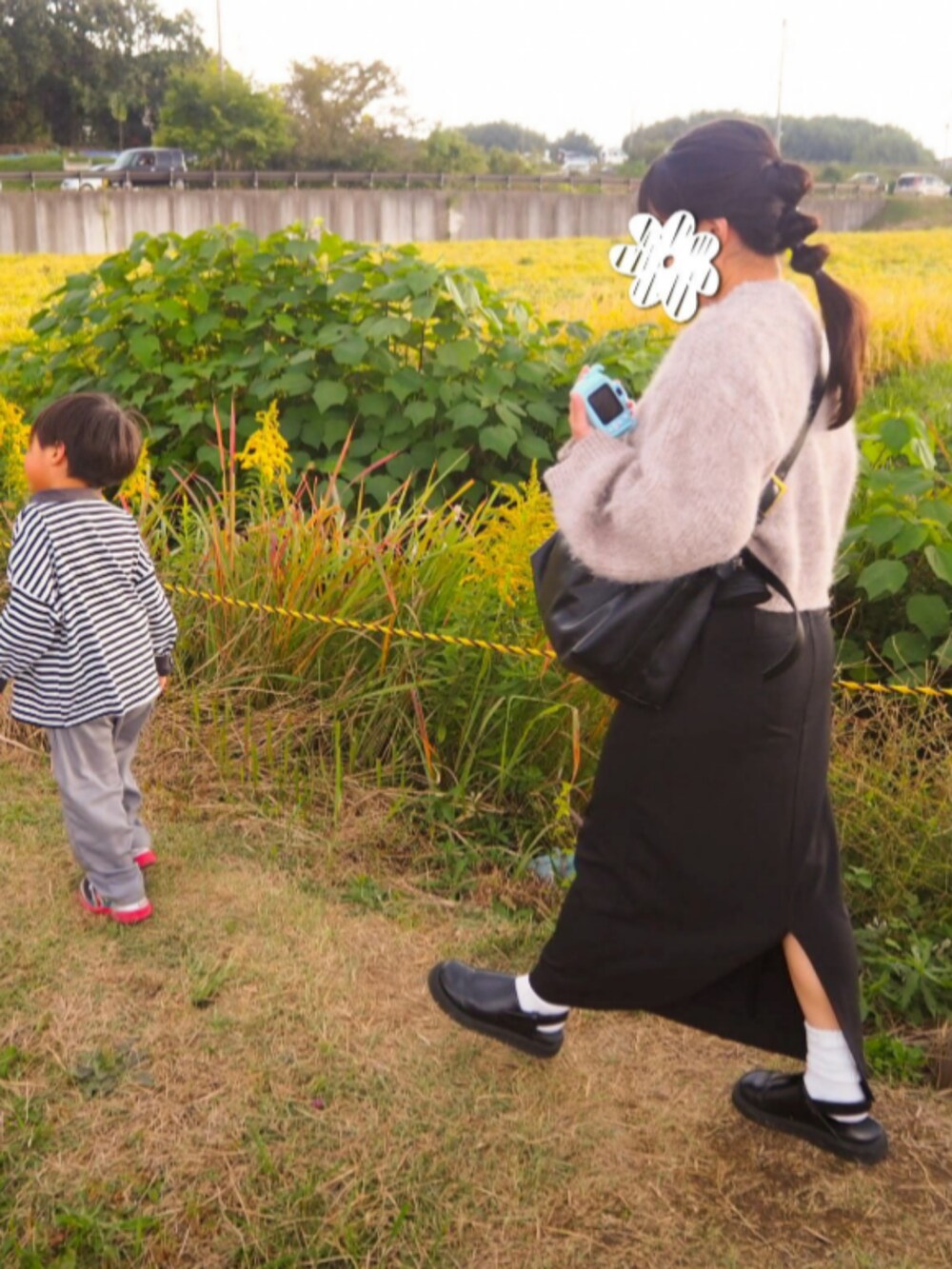 ブラウン系のニット/セーター、ブラック系のスカート、ブラック系のスリッポンを着用したレディースの秋コーディネートの2枚目の写真