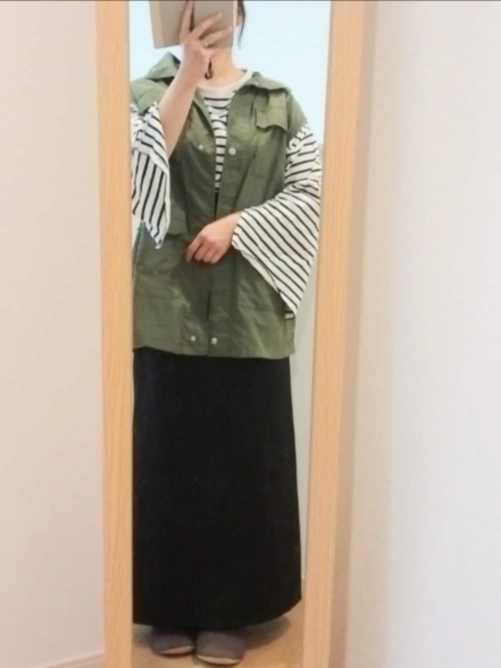 ホワイト系のTシャツ/カットソー、グリーン系のベスト、ブラック系のスカートを着用したレディースの春コーディネートの2枚目の写真