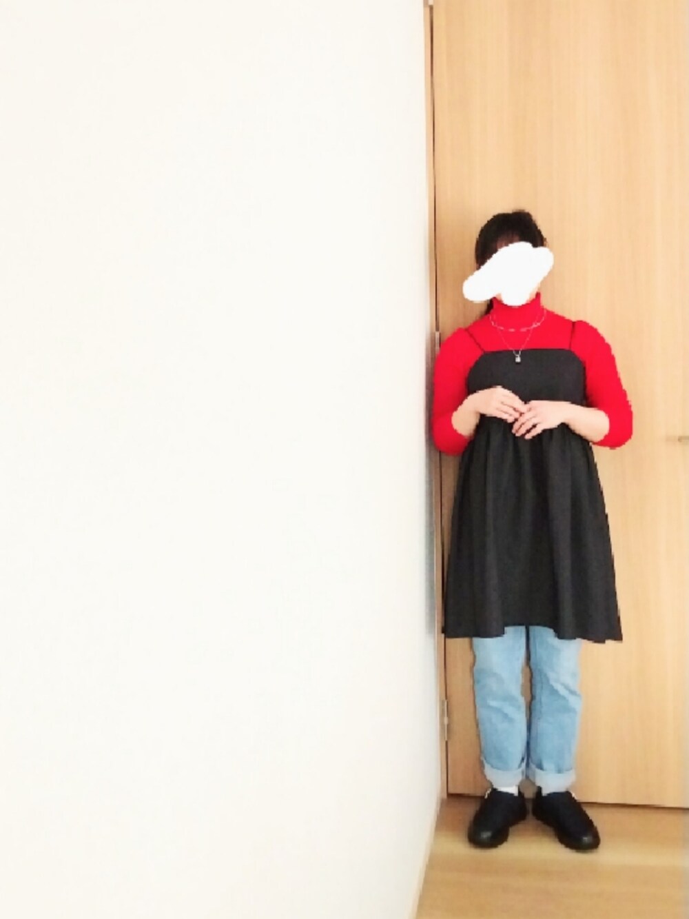 ブラック系のダウンジャケット/コート、レッド系のニット/セーター、ブラック系のワンピースを着用したレディースの冬コーディネートの3枚目の写真