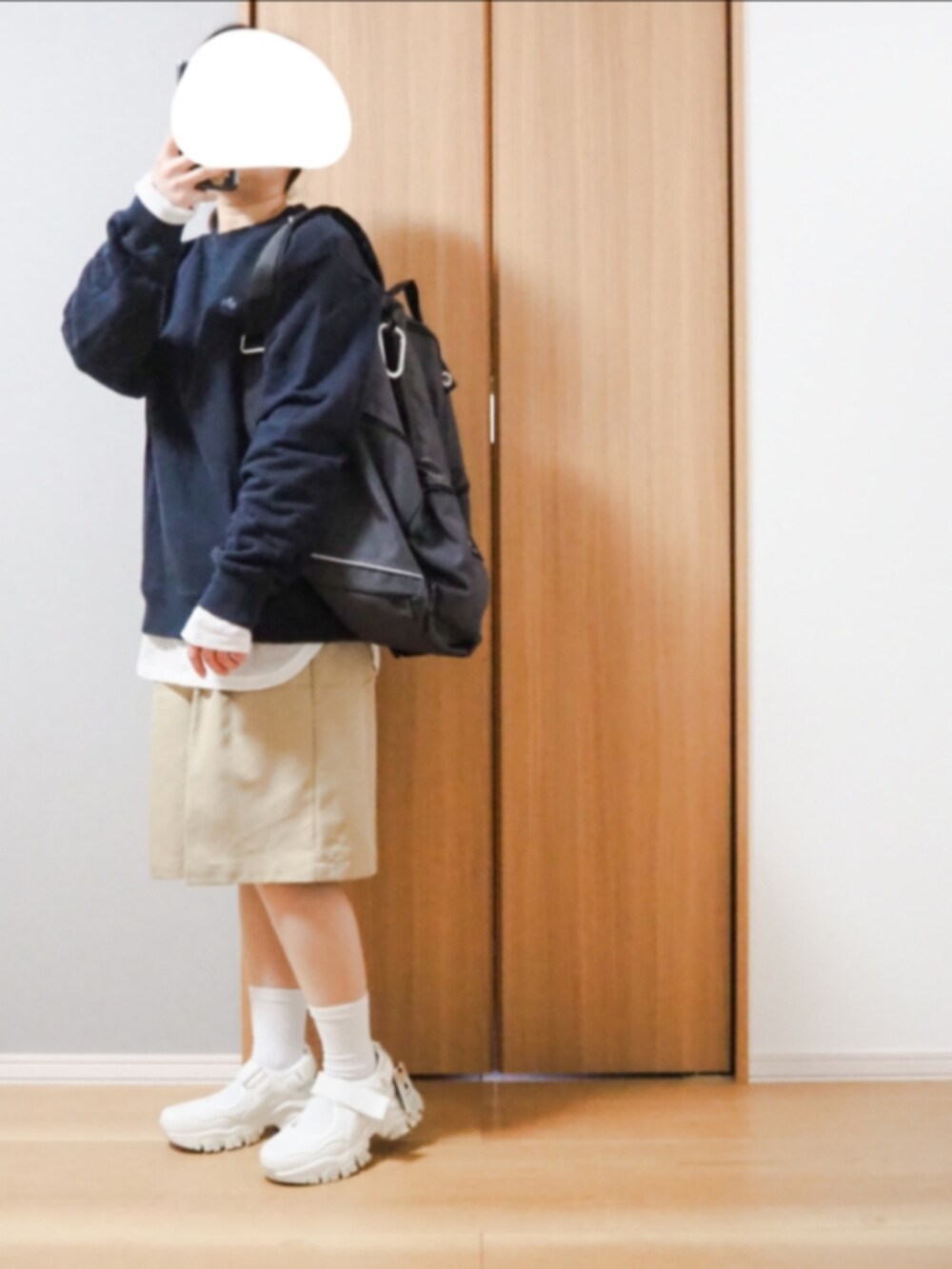 グレー系のバックパック/リュック、ブラック系のスウェット、ホワイト系のTシャツ/カットソーを着用したレディースの春コーディネートの2枚目の写真