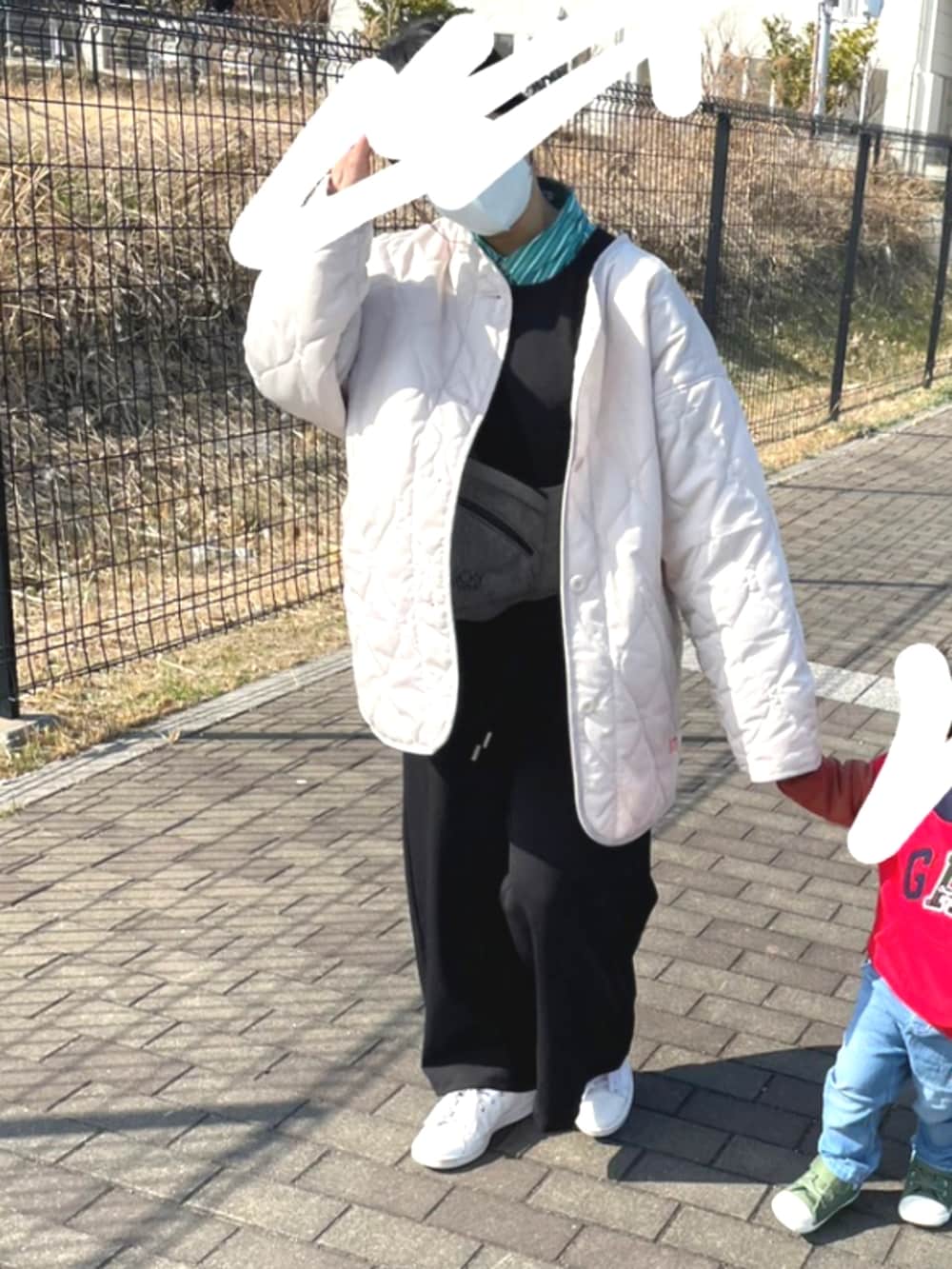 ブラック系のサロペット/オーバーオール、ホワイト系のノーカラージャケット、ブラック系のショルダーバッグを着用したレディースの冬コーディネートの2枚目の写真