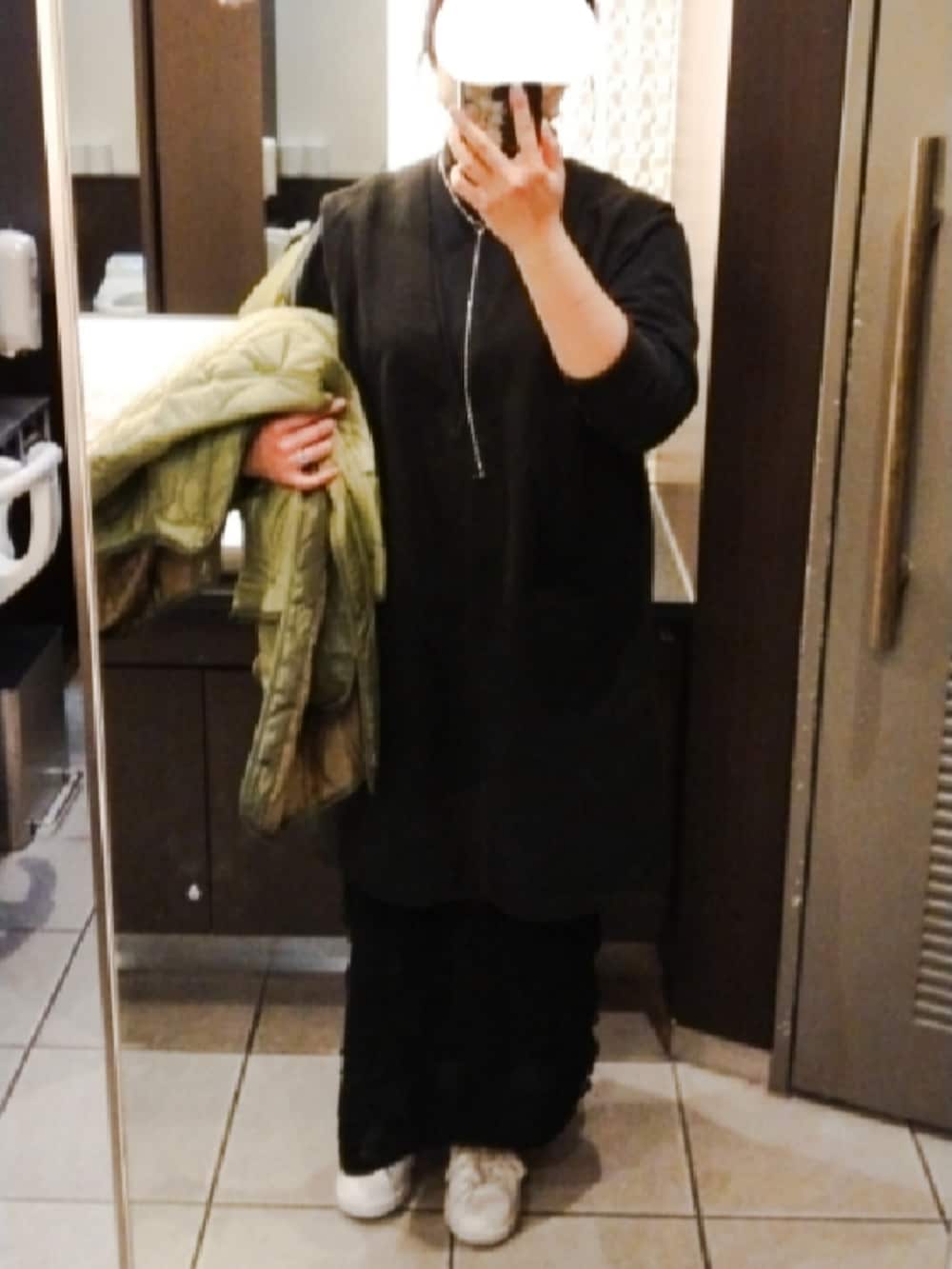 グリーン系のモッズコート、ブラック系のTシャツ/カットソー、ブラック系のベストを着用したレディースの冬コーディネートの2枚目の写真