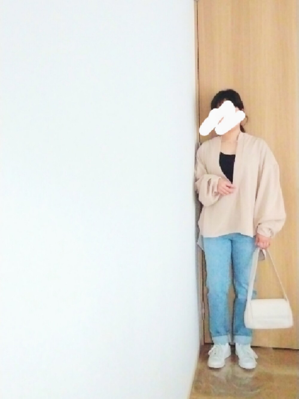 ブラック系のダウンジャケット/コート、ベージュ系のTシャツ/カットソー、ブルー系のデニムパンツを着用したレディースの冬コーディネートの2枚目の写真