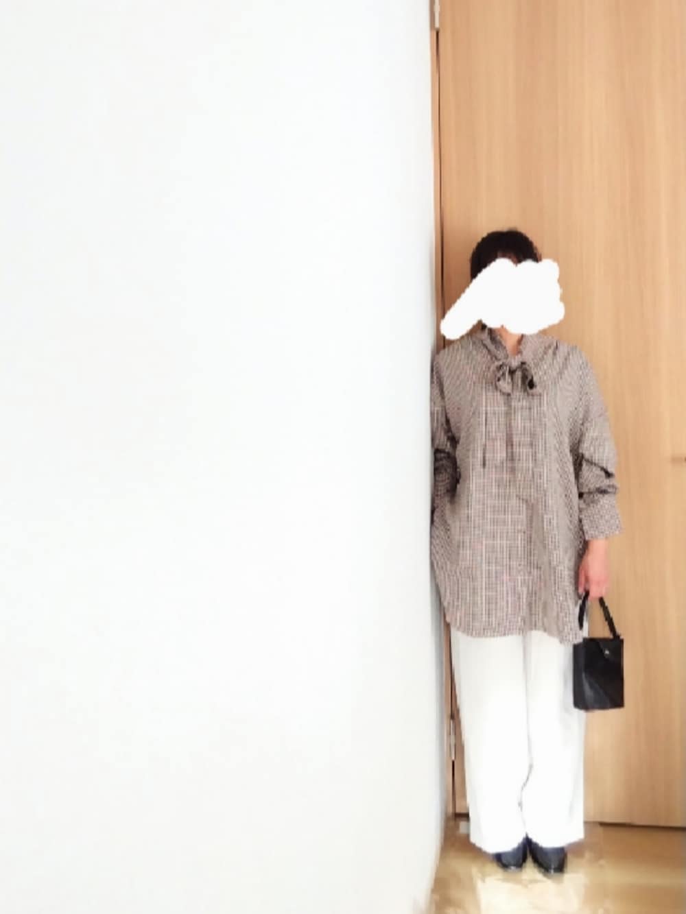 ブラック系のシャツ/ブラウス、ホワイト系のスラックス、ブラック系のローファーを着用したレディースの秋コーディネートの2枚目の写真