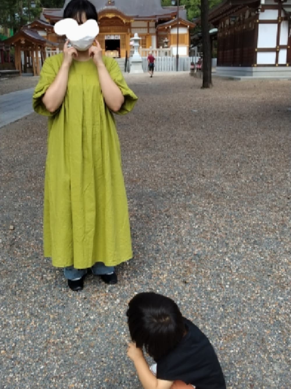 グリーン系のワンピース、ブルー系のデニムパンツ、ブラック系のバレエシューズを着用したレディースの秋コーディネートの2枚目の写真