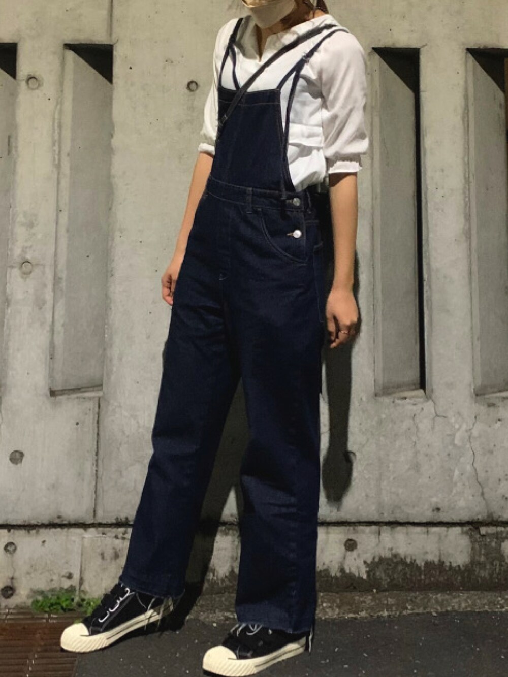 ブルー系のサロペット/オーバーオール、ホワイト系のシャツ/ブラウス、ブラック系のスニーカーを着用したレディースの春コーディネートの2枚目の写真