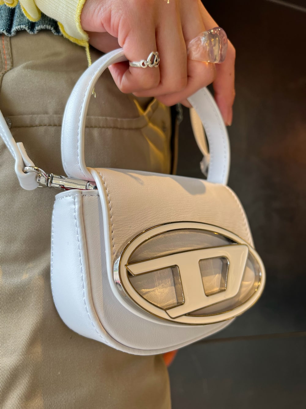 ベージュ系のその他パンツ、ホワイト系のその他シューズ、ホワイト系のショルダーバッグを着用したレディースの春コーディネートの2枚目の写真