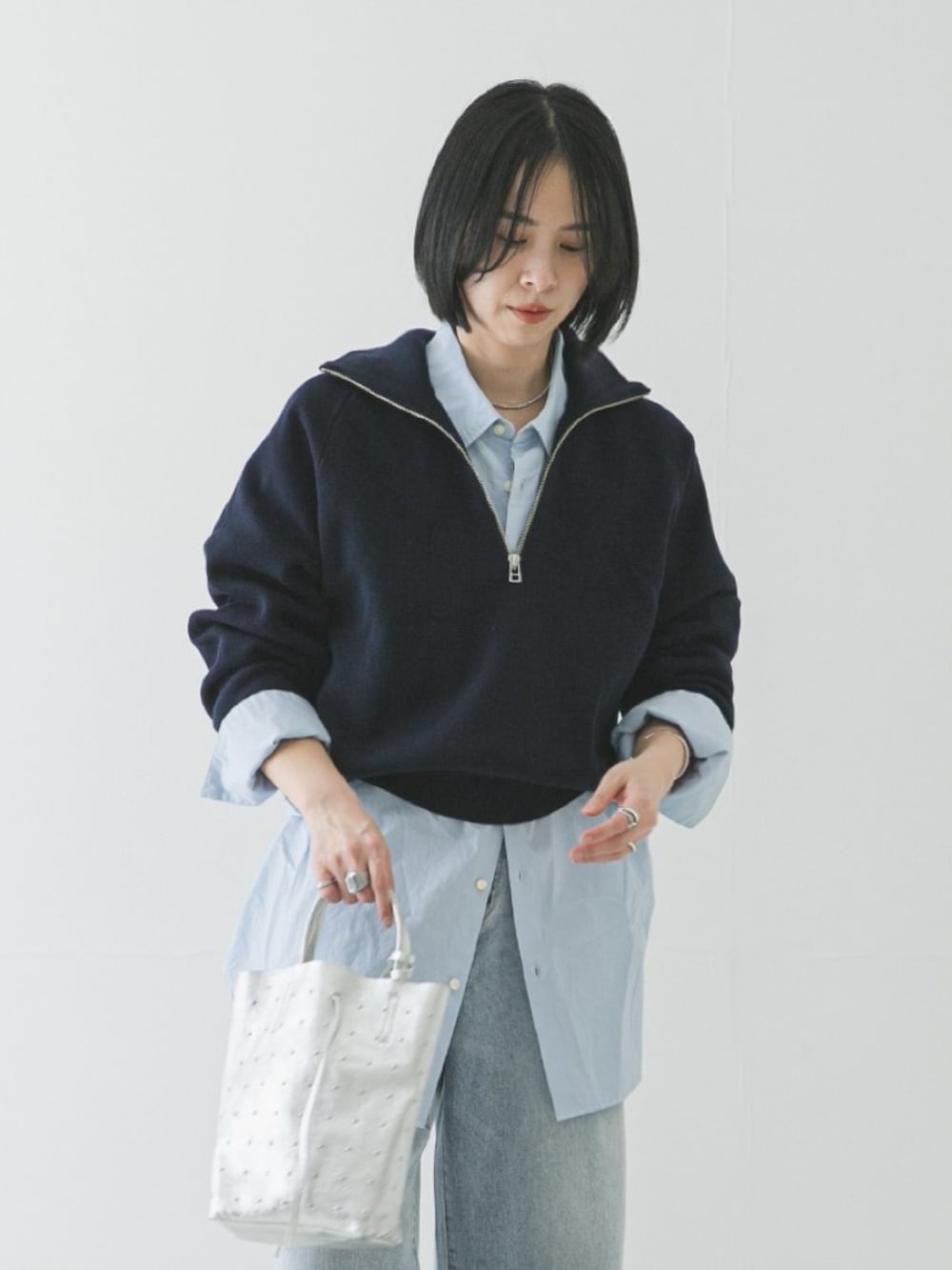 ブルー系のスウェット、ピンク系のシャツ/ブラウス、ブルー系のデニムパンツを着用したレディースの冬コーディネートの3枚目の写真