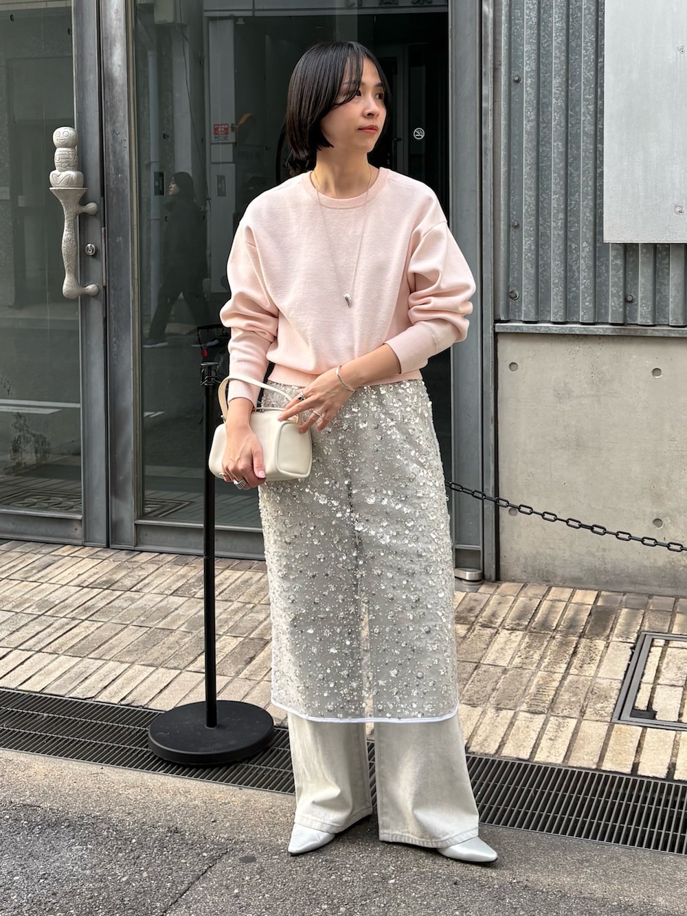 ホワイト系のスカート、グレー系のデニムパンツ、ピンク系のニット/セーターを着用したレディースの冬コーディネートの2枚目の写真