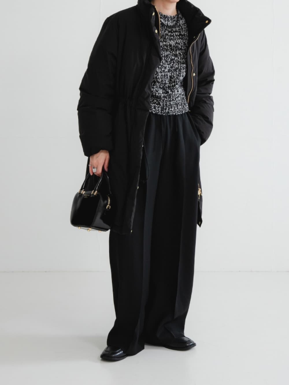 ブラック系のダウンジャケット/コート、ブラック系のニット/セーター、ブラック系のその他パンツを着用したレディースの冬コーディネートの2枚目の写真