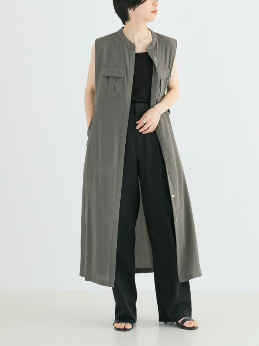 グリーン系のワンピース、ブラック系のキャミソール、ブラック系のその他パンツを着用したレディースの春コーディネートの2枚目の写真