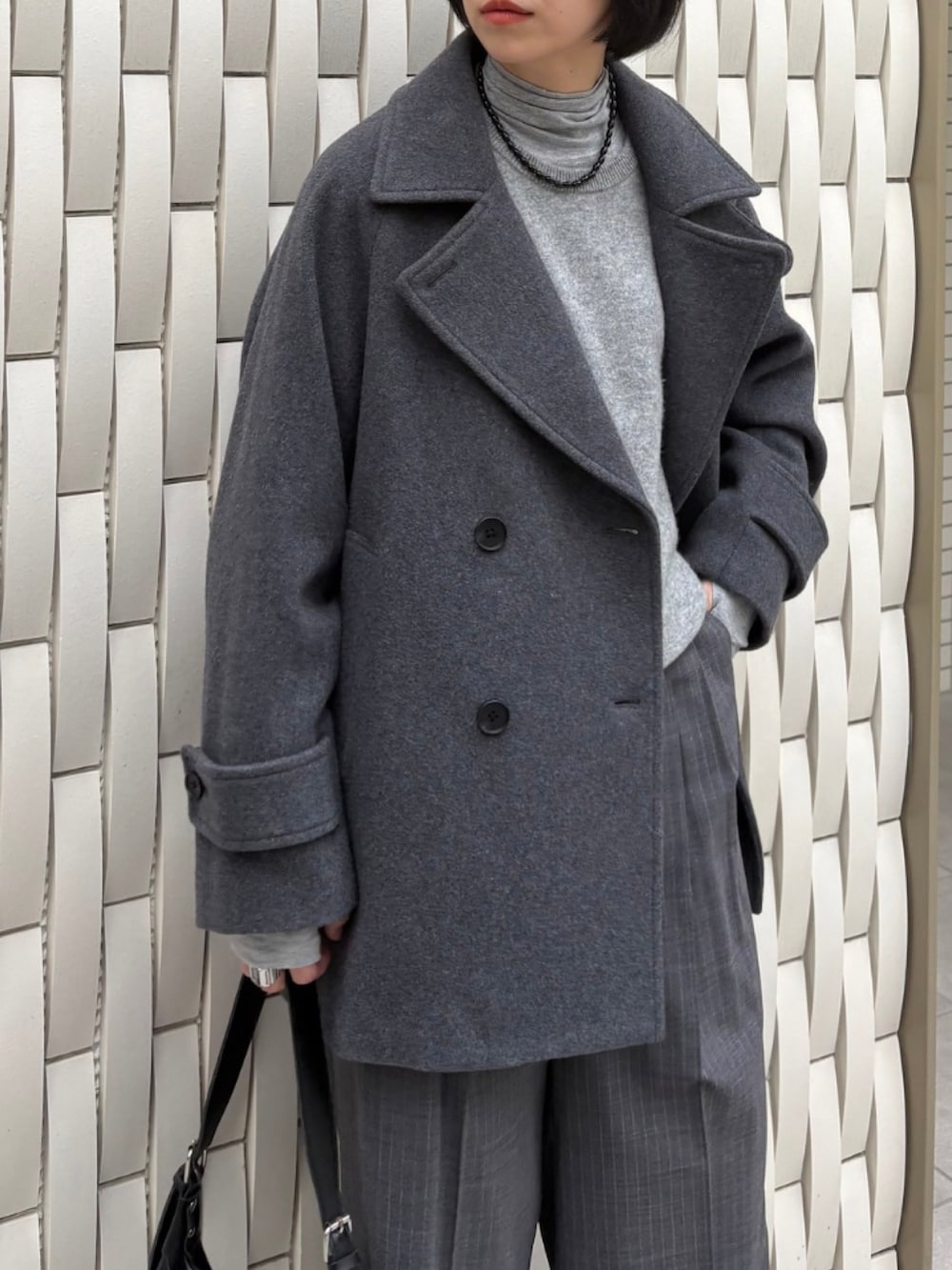 グレー系のピーコート、グリーン系のニット/セーター、グレー系のその他パンツを着用したレディースの秋コーディネートの4枚目の写真