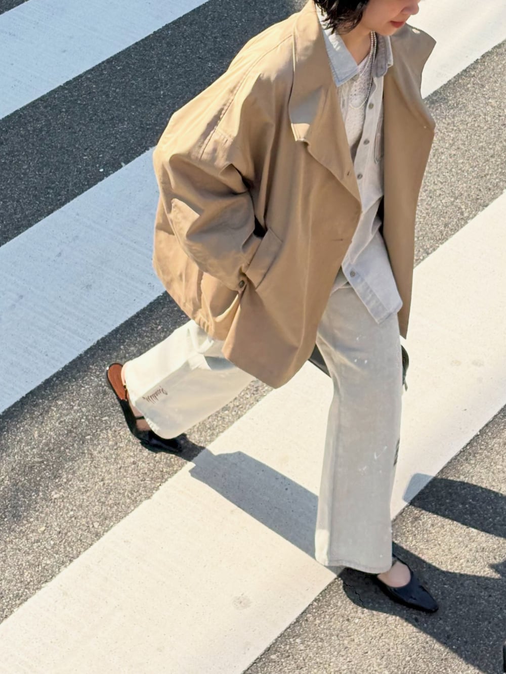 グレー系のシャツ/ブラウス、ベージュ系のトレンチコート、ホワイト系のTシャツ/カットソーを着用したレディースの冬コーディネートの4枚目の写真