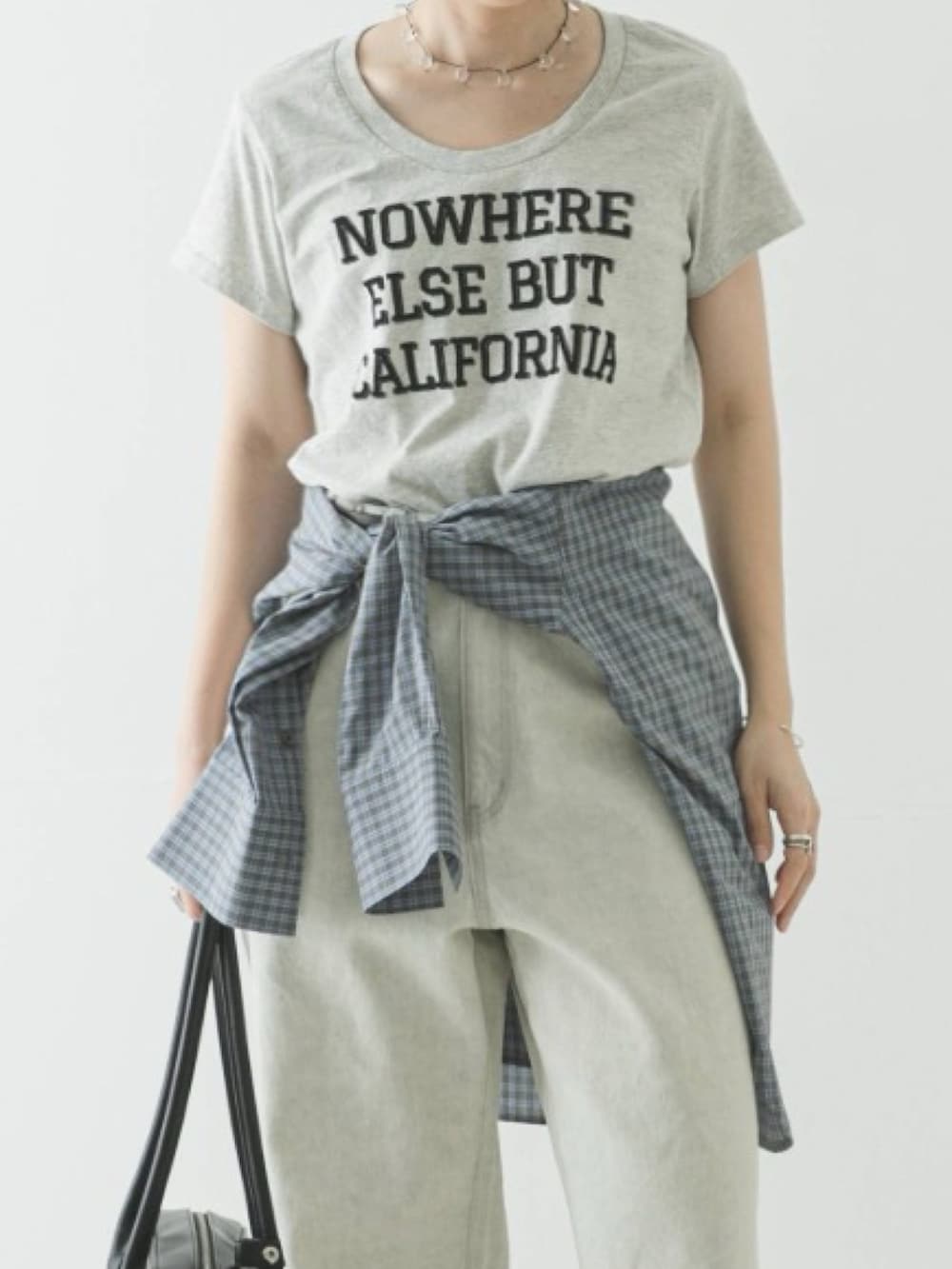 グレー系のTシャツ/カットソー、ブルー系のシャツ/ブラウス、グレー系のデニムパンツを着用したレディースの春コーディネートの2枚目の写真
