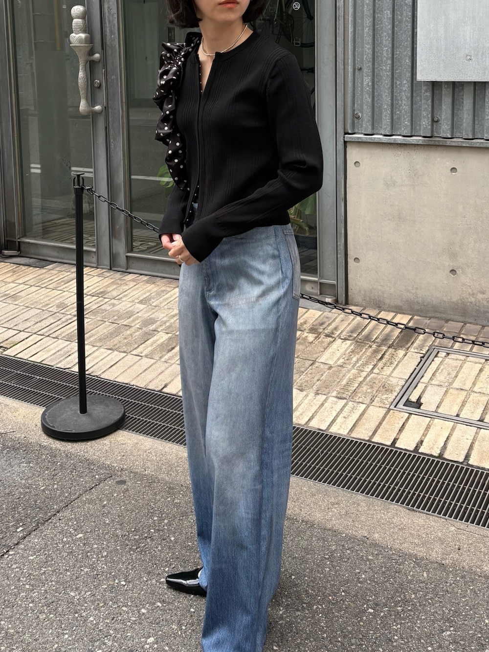 ブルー系のその他パンツ、ブラック系のパンプス、ホワイト系のショルダーバッグを着用したレディースの春コーディネートの2枚目の写真