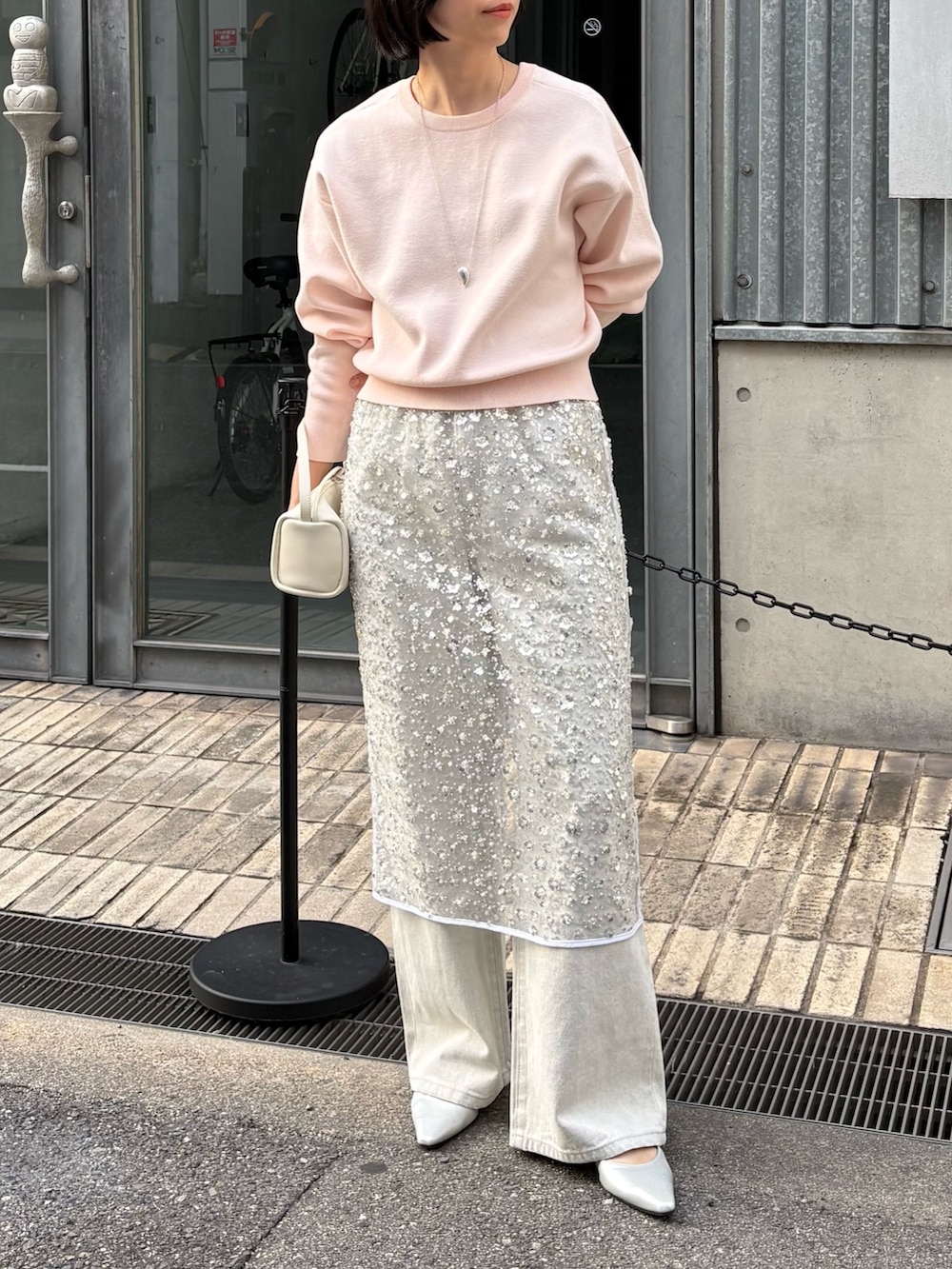 ホワイト系のスカート、グレー系のデニムパンツ、ピンク系のニット/セーターを着用したレディースの冬コーディネートの3枚目の写真