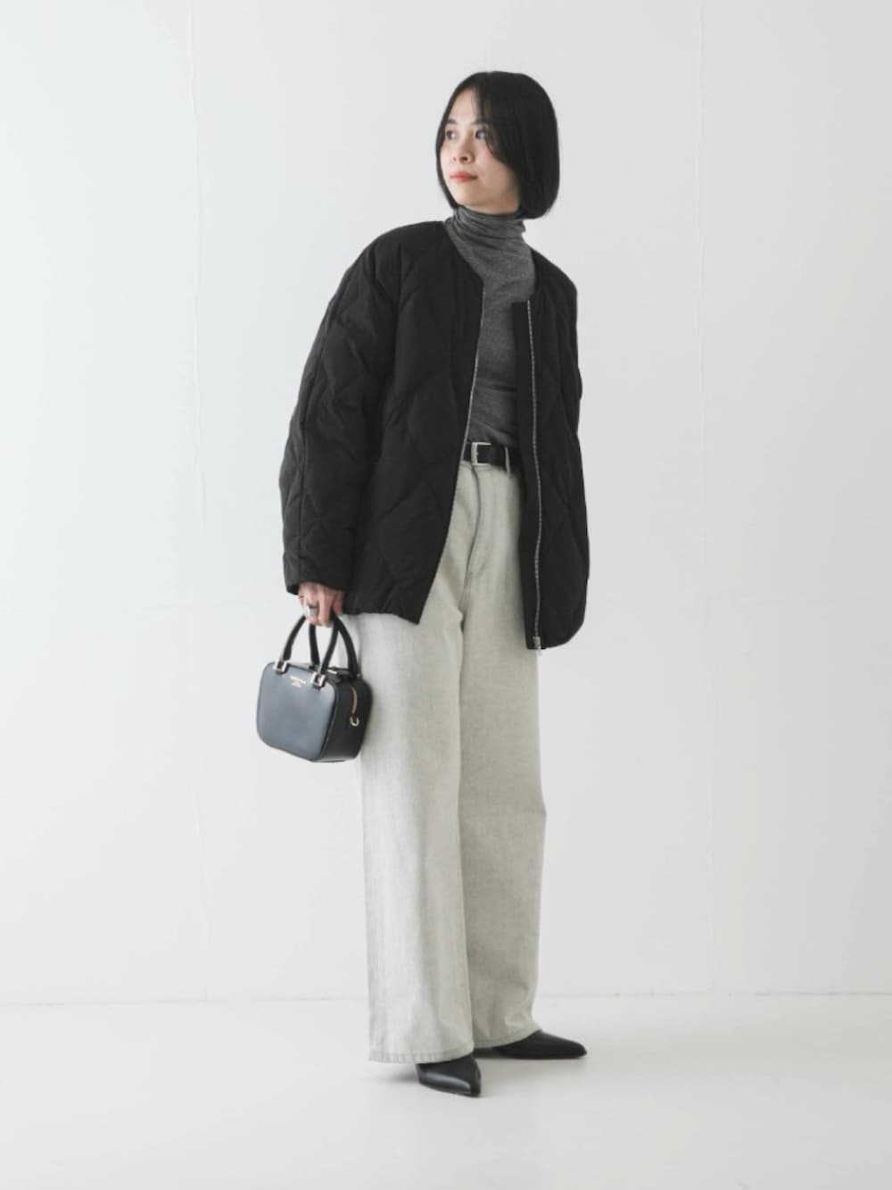 ブラック系のダウンジャケット/コート、ブラック系のTシャツ/カットソー、ブラック系のショルダーバッグを着用したレディースの冬コーディネートの2枚目の写真