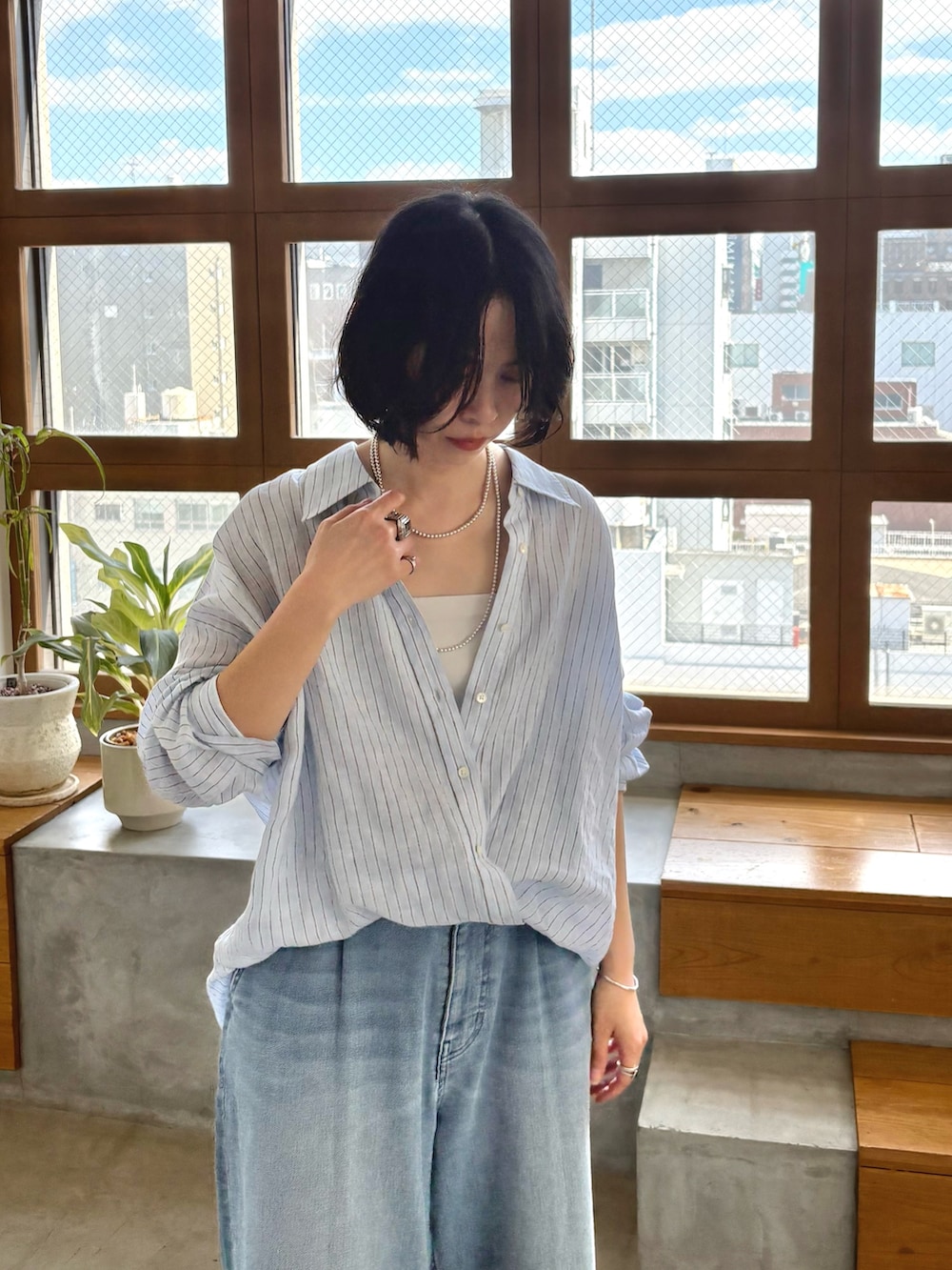 ブルー系のシャツ/ブラウス、ブルー系のデニムパンツ、ブラック系のパンプスを着用したレディースの冬コーディネートの4枚目の写真