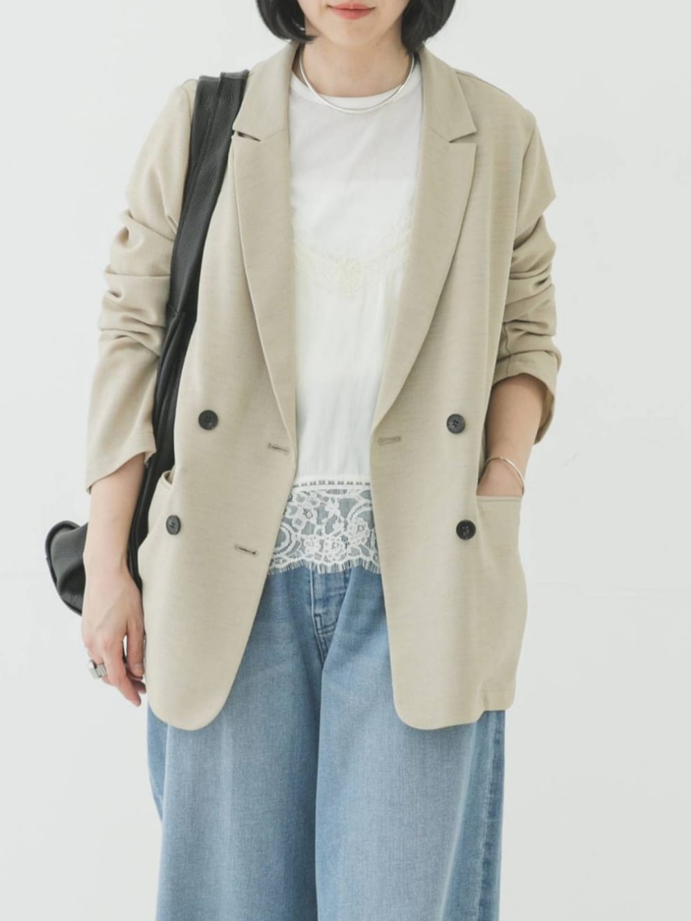 ベージュ系のその他アウター、ブルー系のデニムパンツ、ホワイト系のキャミソールを着用したレディースの春コーディネートの3枚目の写真