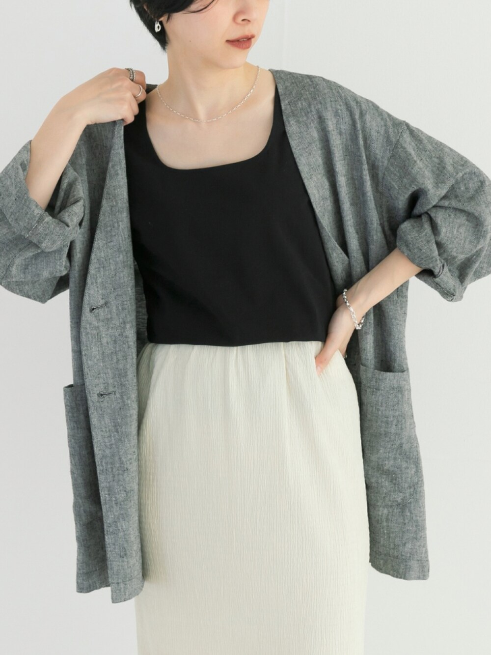 ブラック系のタンクトップ、ブラック系のノーカラージャケット、ホワイト系のスカートを着用したレディースの春コーディネートの3枚目の写真