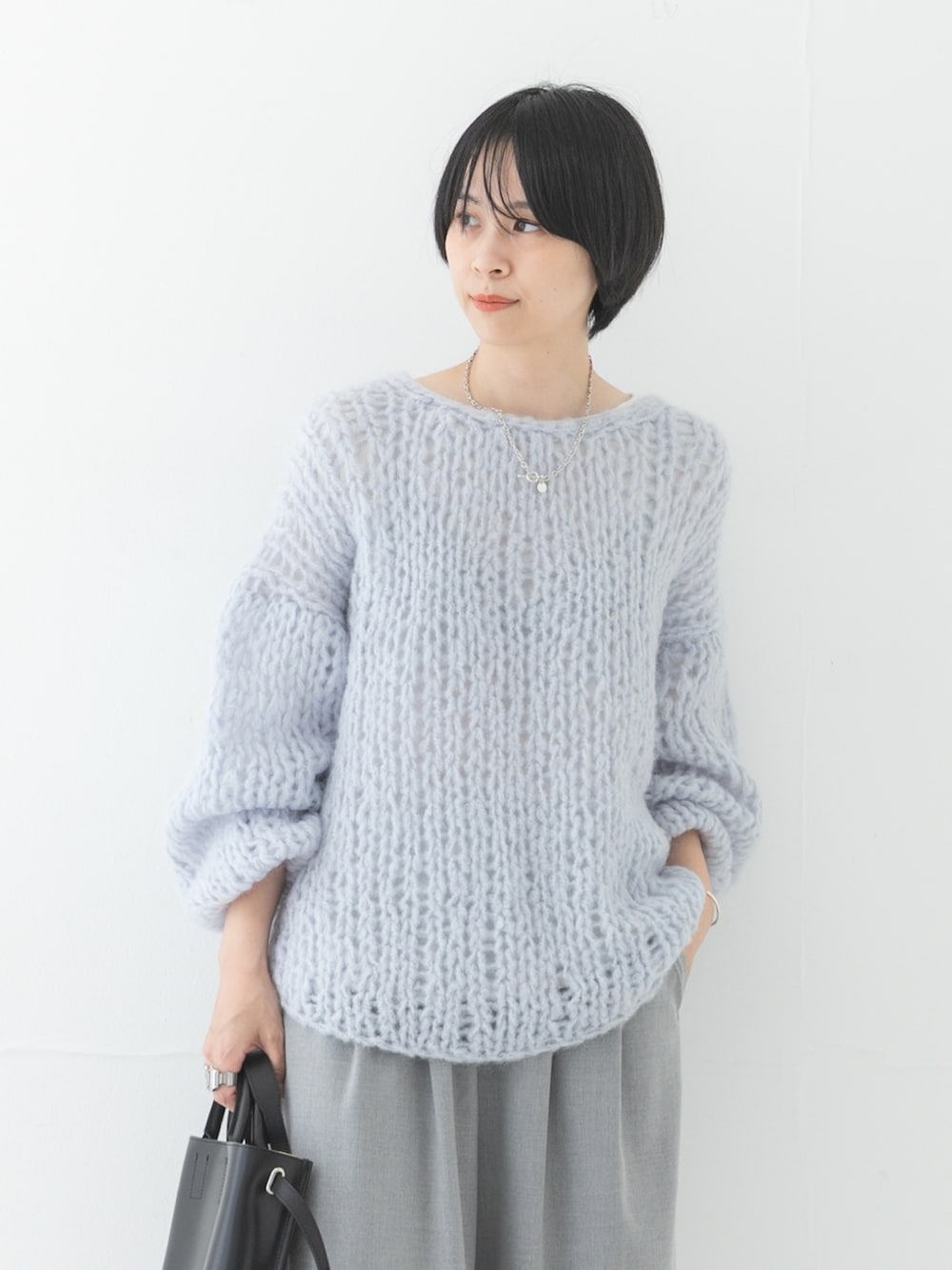 ブルー系のニット/セーター、ブラック系のサンダル、ブラック系のショルダーバッグを着用したレディースの秋コーディネートの3枚目の写真