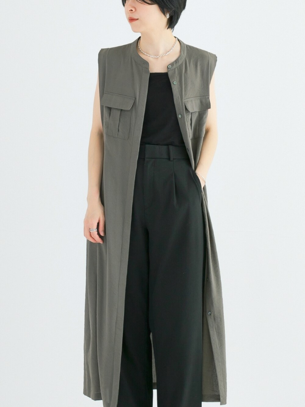 グリーン系のワンピース、ブラック系のキャミソール、ブラック系のその他パンツを着用したレディースの春コーディネートの3枚目の写真