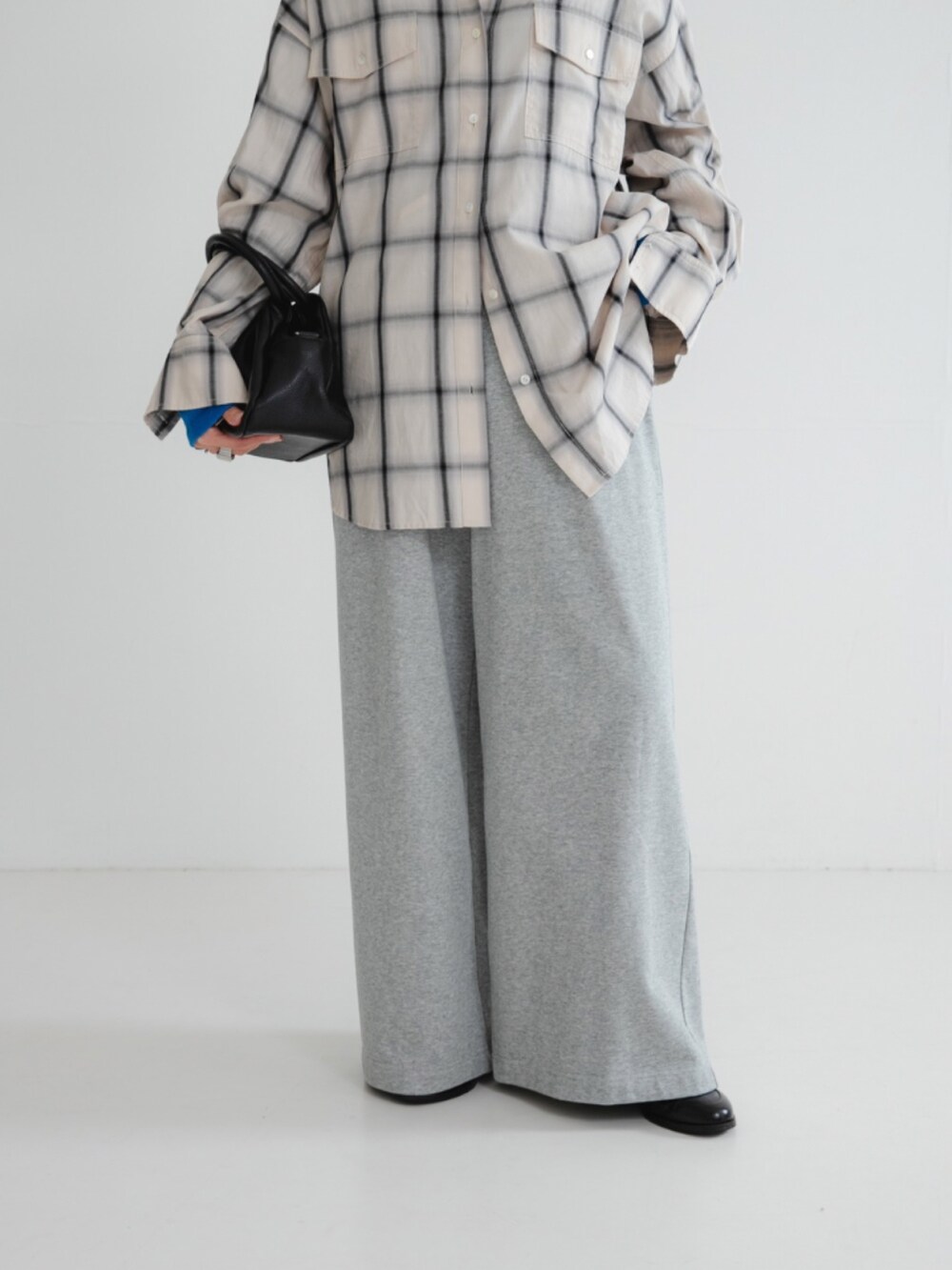 ブルー系のTシャツ/カットソー、ホワイト系のシャツ/ブラウス、ブラック系のハンドバッグを着用したレディースの秋コーディネートの3枚目の写真