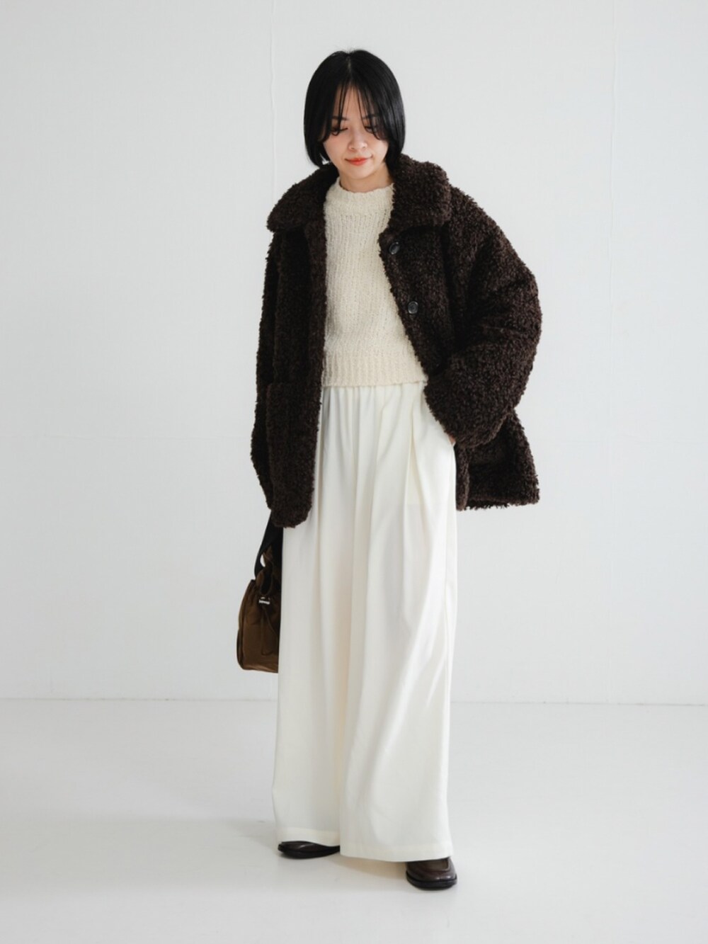 ブラウン系のその他アウター、ホワイト系のニット/セーター、ホワイト系のその他パンツを着用したレディースの冬コーディネートの3枚目の写真