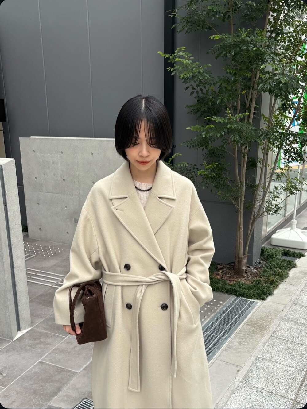 ベージュ系のその他パンツ、ベージュ系のチェスターコート、ホワイト系のニット/セーターを着用したレディースの秋コーディネートの4枚目の写真