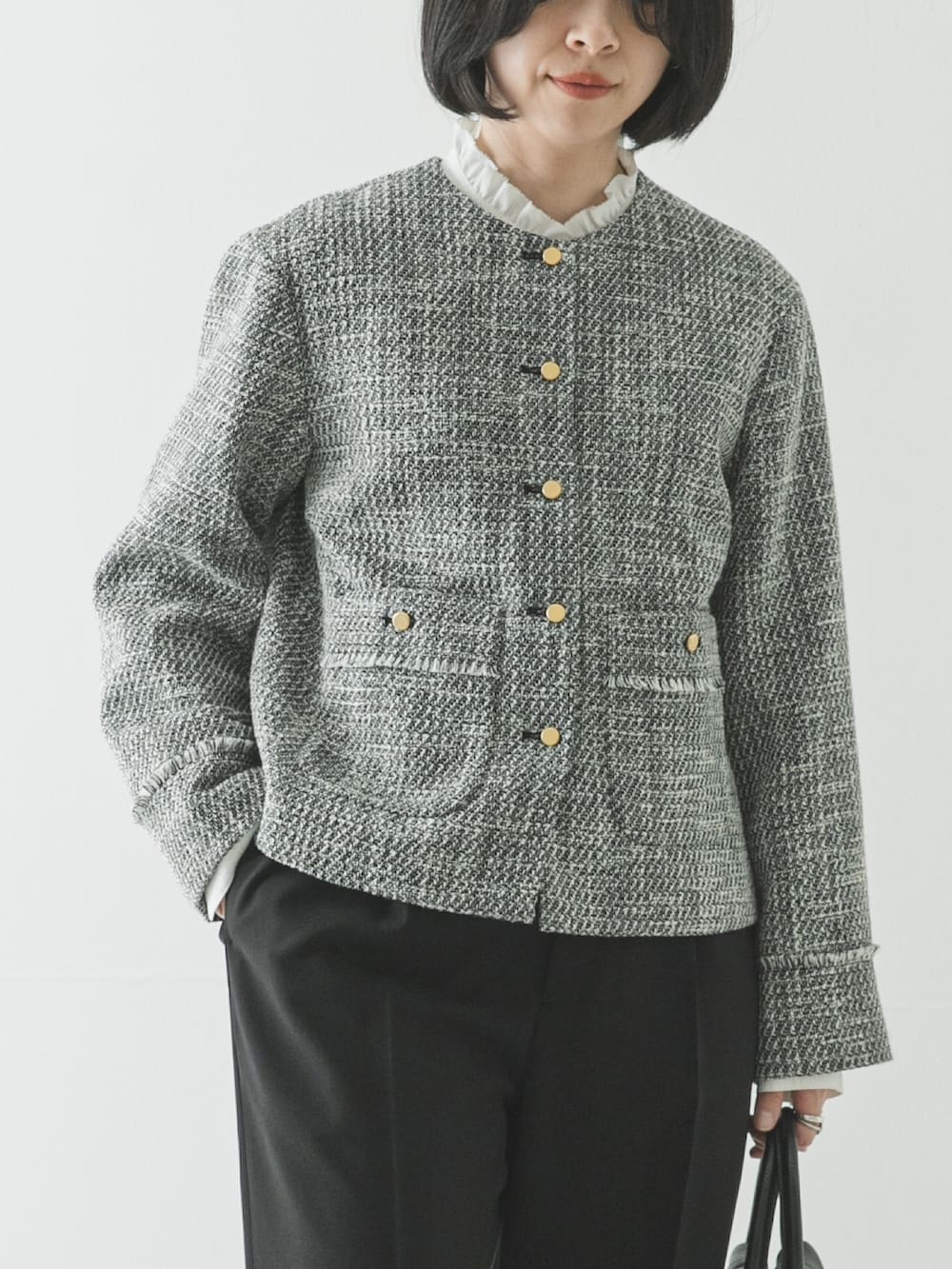 ブラック系のノーカラージャケット、ホワイト系のシャツ/ブラウス、ブラック系のその他パンツを着用したレディースの春コーディネートの3枚目の写真