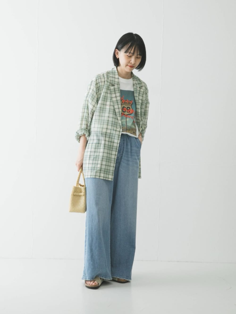 グリーン系のその他アウター、ホワイト系のTシャツ/カットソー、ベージュ系のサンダルを着用したレディースの春コーディネートの2枚目の写真