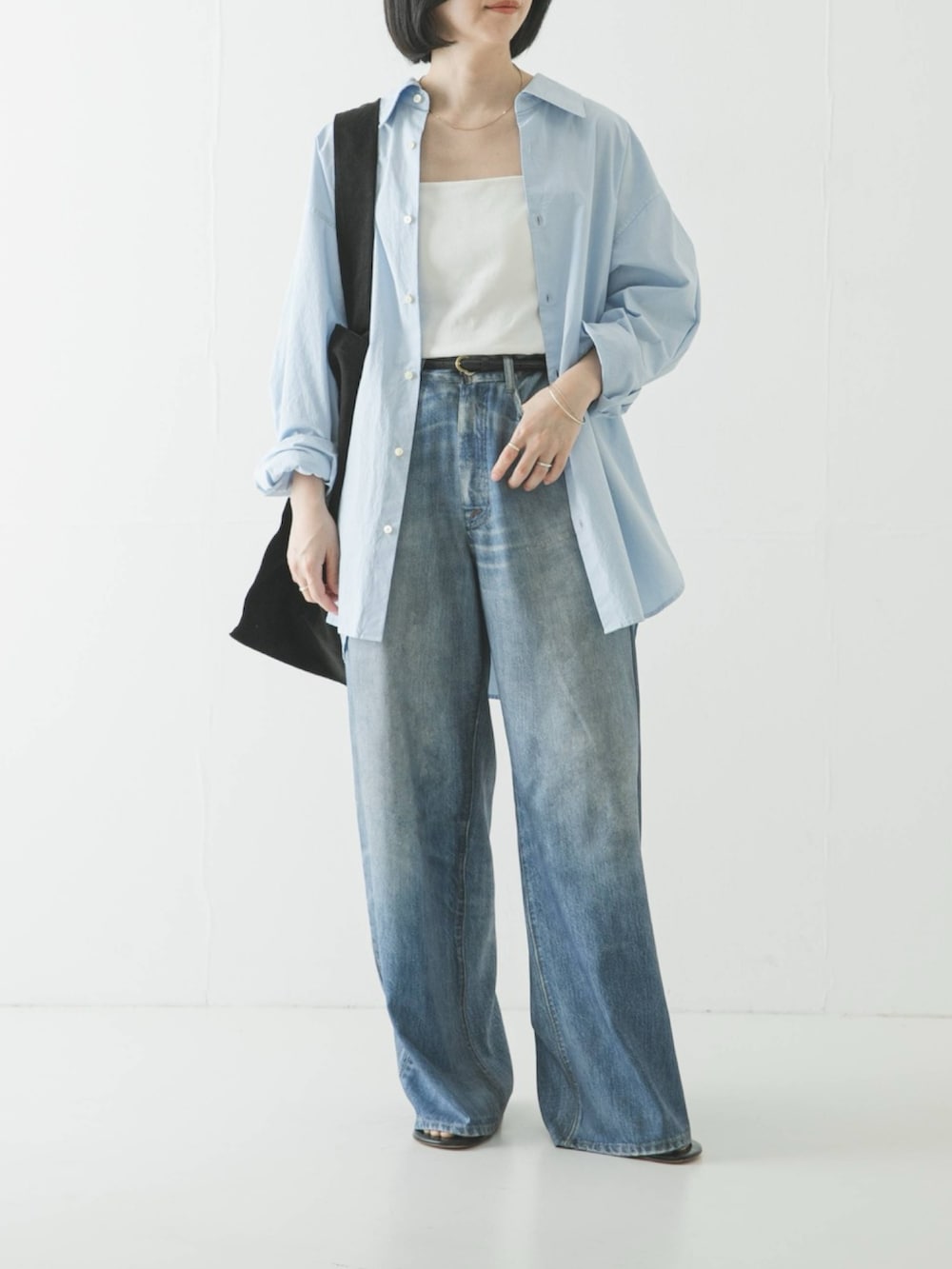 ホワイト系のキャミソール、ブルー系のシャツ/ブラウス、ブラック系のトートバッグを着用したレディースの春コーディネートの2枚目の写真