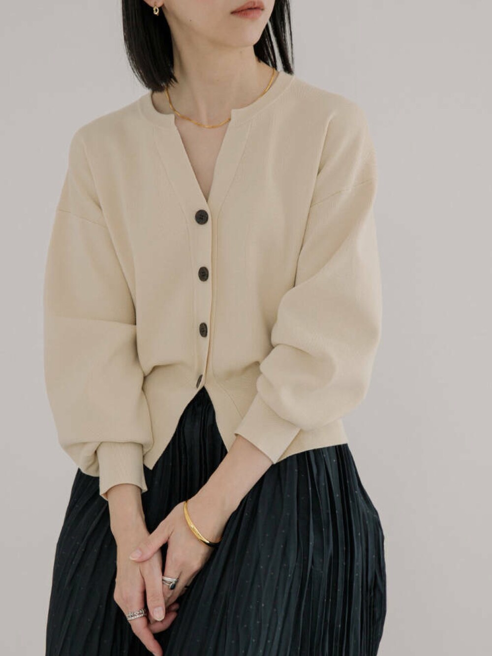 ホワイト系のカーディガン/ボレロ、ブラック系のスカートを着用したレディースの冬コーディネートの2枚目の写真