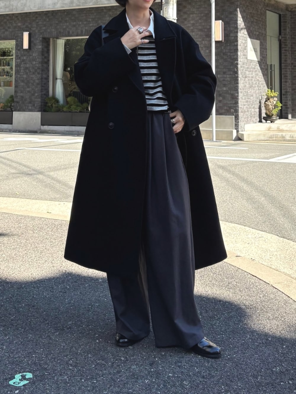 ブラック系のチェスターコート、グレー系のTシャツ/カットソー、グレー系のTシャツ/カットソーを着用したレディースの秋コーディネートの2枚目の写真