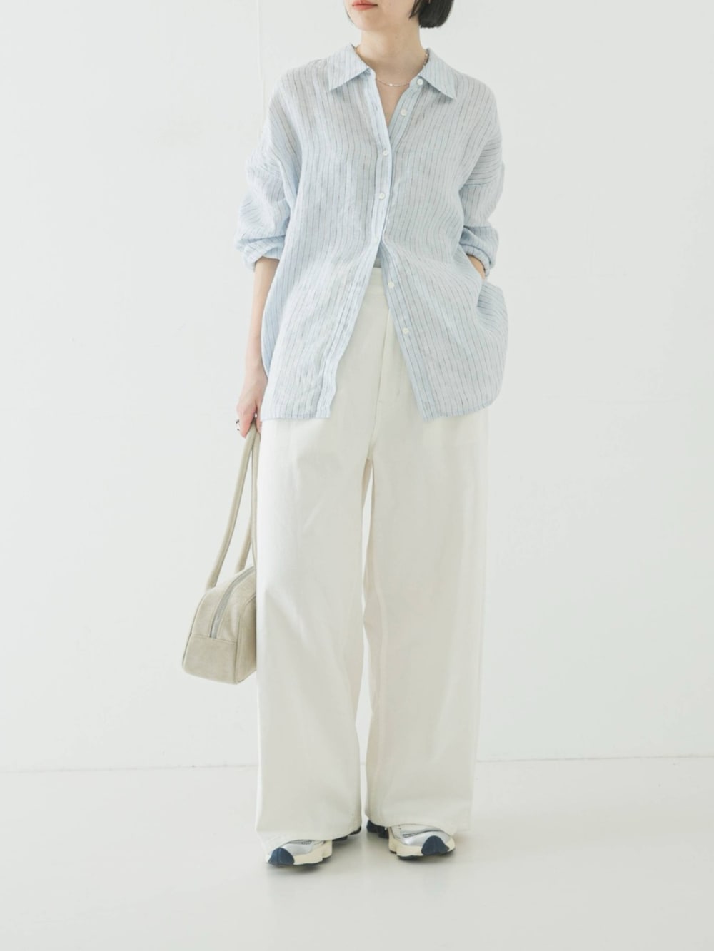 ブルー系のシャツ/ブラウス、ホワイト系のショルダーバッグ、ホワイト系のその他パンツを着用したレディースの春コーディネートの2枚目の写真