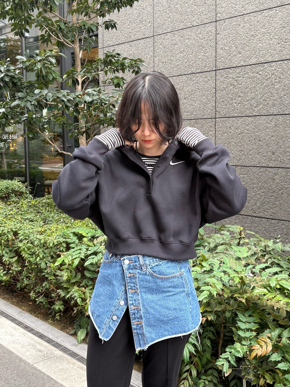 ブラック系のパーカー、ブラック系のスニーカーを着用したレディースの春コーディネートの3枚目の写真