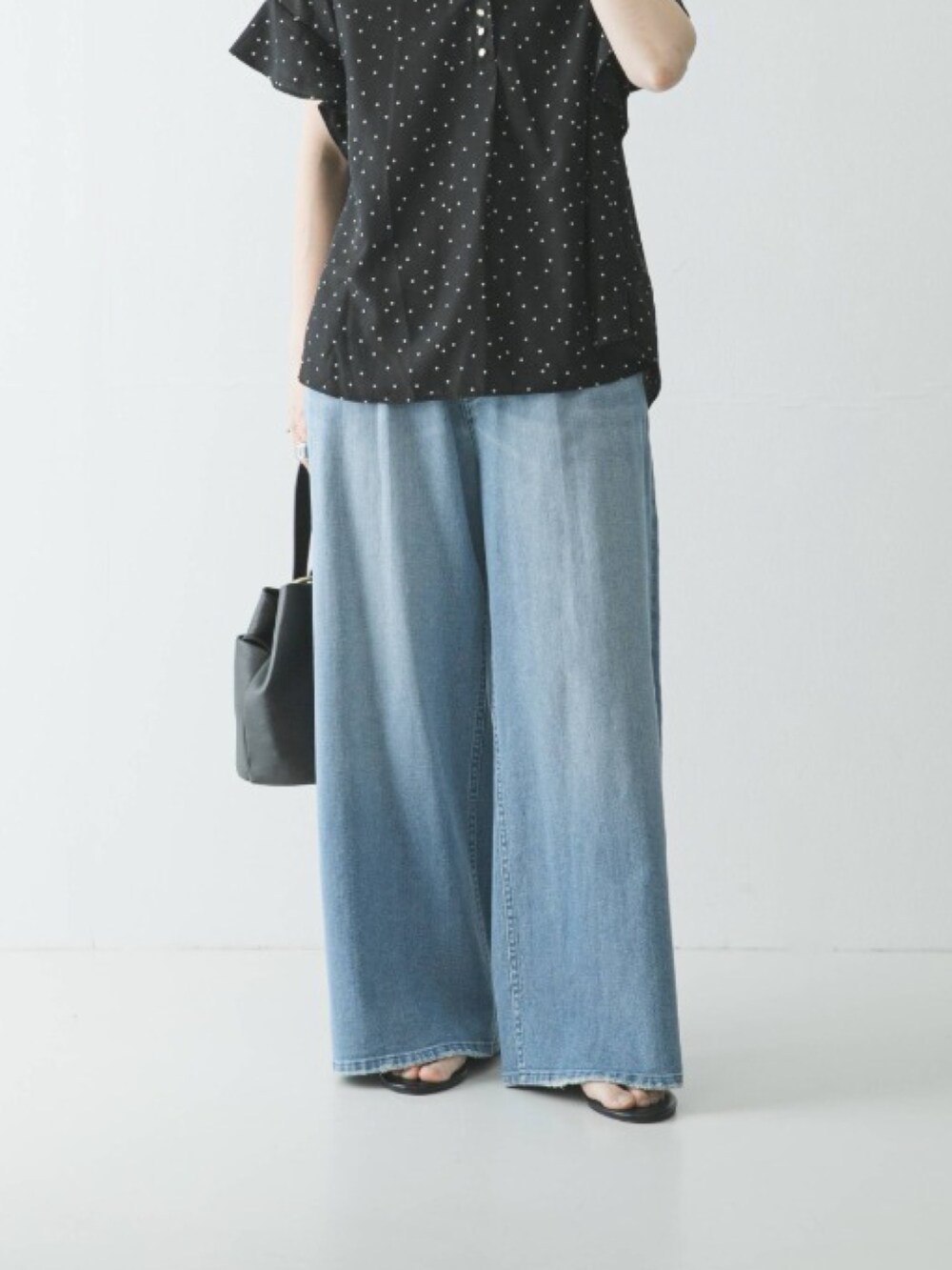 ブラック系のシャツ/ブラウス、ブルー系のデニムパンツ、ブラック系のハンドバッグを着用したレディースの春コーディネートの3枚目の写真