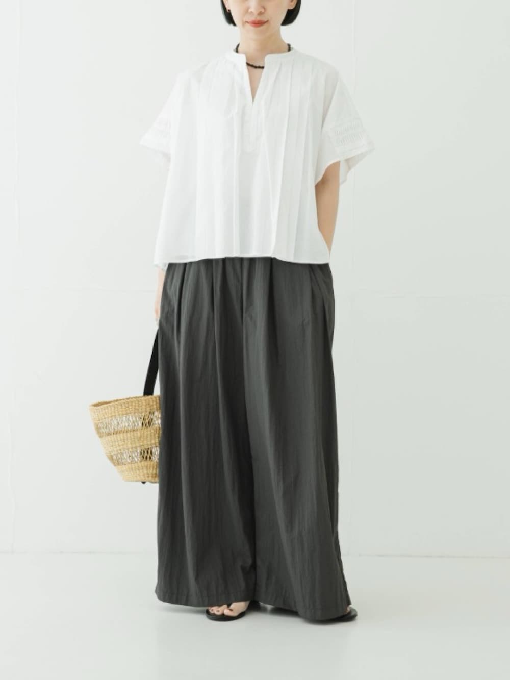 ホワイト系のシャツ/ブラウス、グレー系のその他パンツ、ベージュ系のかごバッグを着用したレディースの夏コーディネートの2枚目の写真