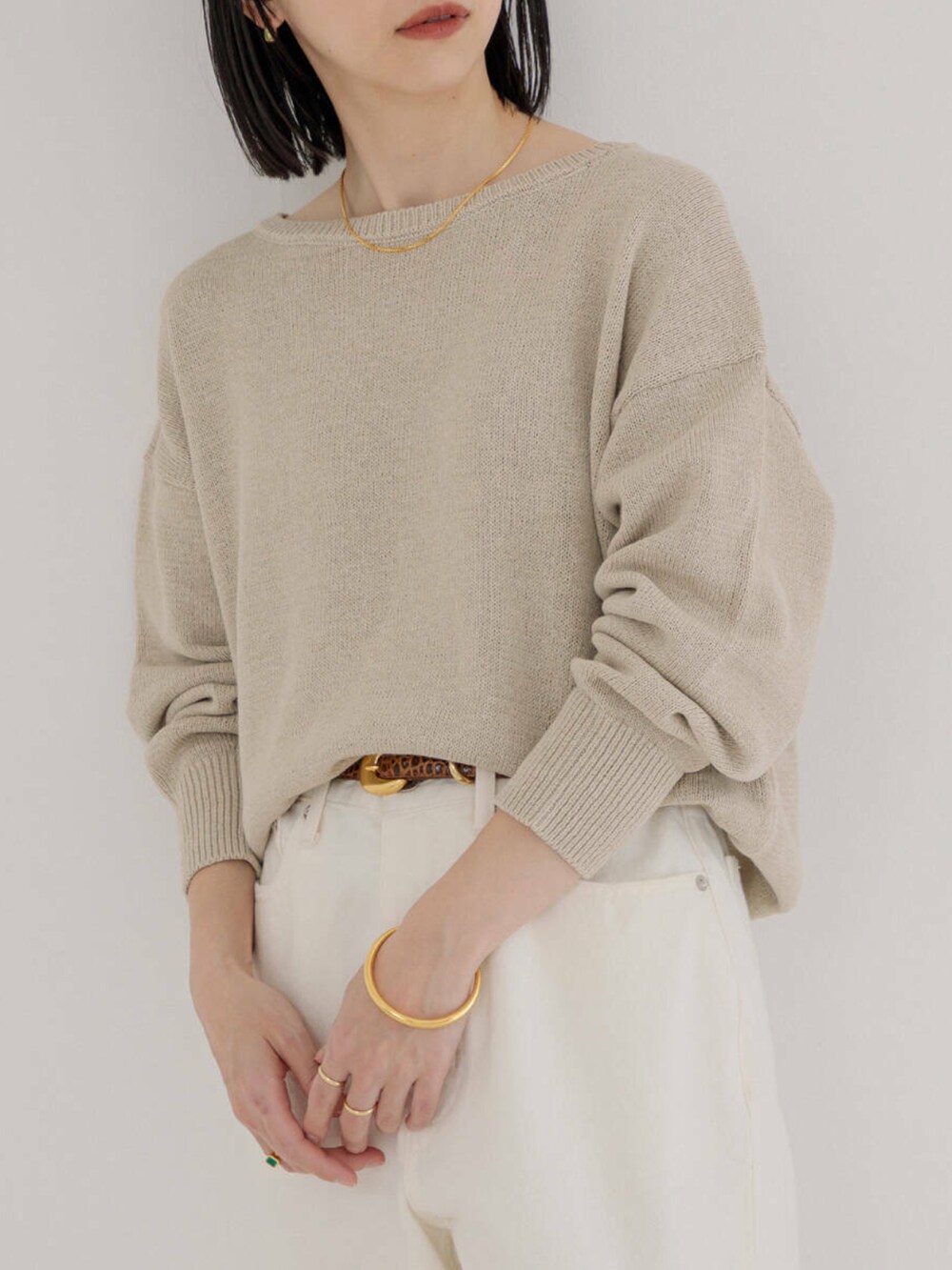 ホワイト系のデニムパンツ、ベージュ系のニット/セーターを着用したレディースの冬コーディネートの2枚目の写真