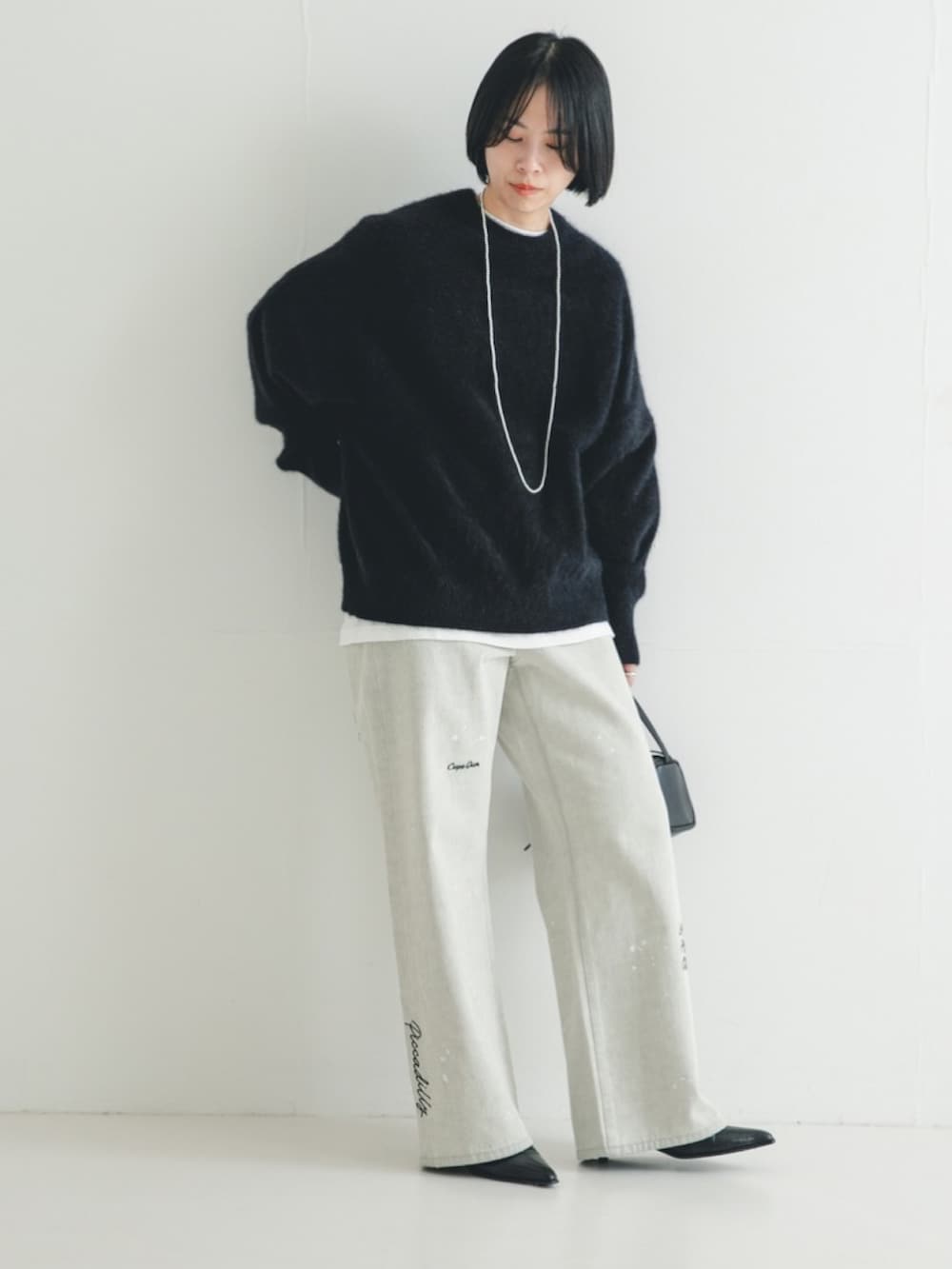 ブラック系のニット/セーター、グレー系のデニムパンツ、ブラック系のブーツを着用したレディースの冬コーディネートの2枚目の写真