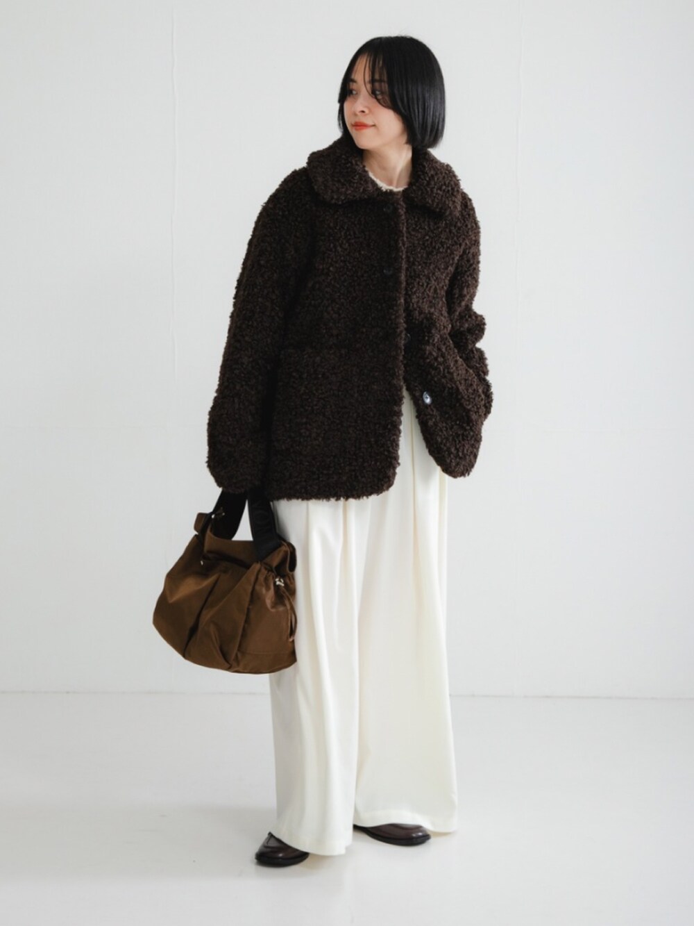 ブラウン系のその他アウター、ホワイト系のニット/セーター、ホワイト系のその他パンツを着用したレディースの冬コーディネートの2枚目の写真