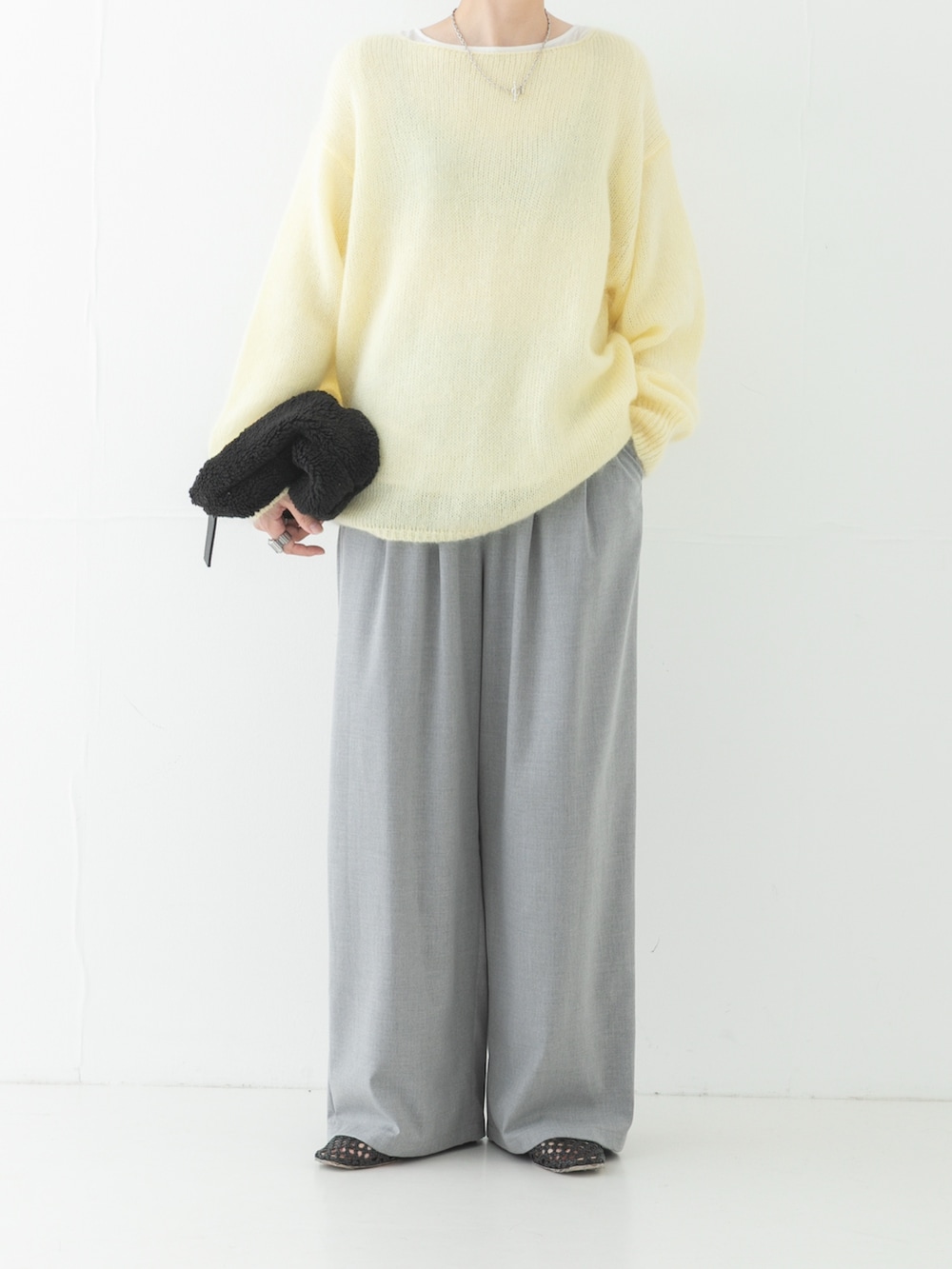 ホワイト系のTシャツ/カットソー、イエロー系のニット/セーター、グレー系のその他パンツを着用したレディースの秋コーディネートの2枚目の写真
