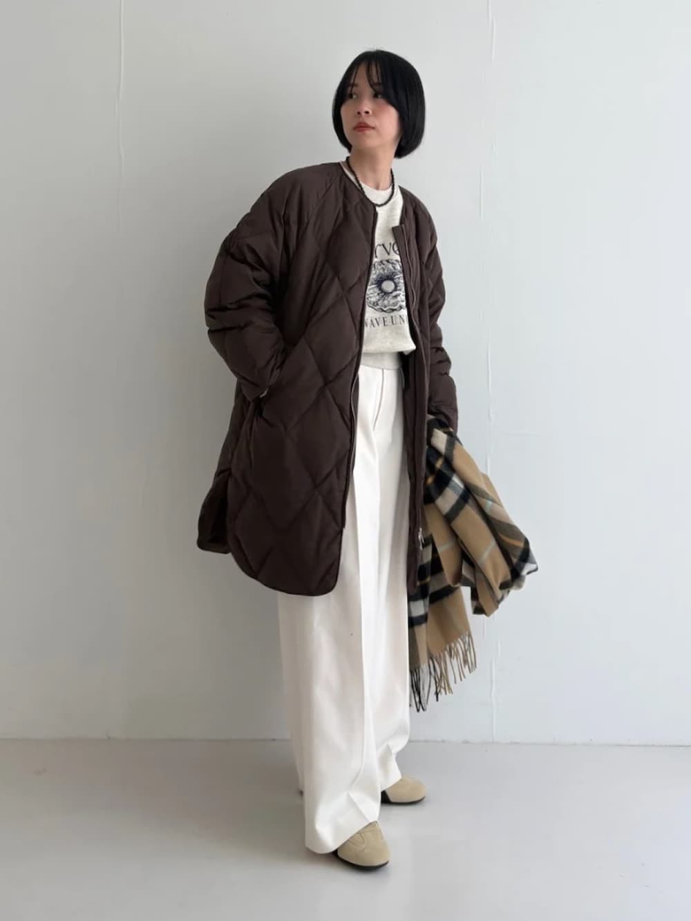 ベージュ系のスニーカー、ホワイト系のその他パンツ、ブラウン系のダウンジャケット/コートを着用したレディースの秋コーディネートの2枚目の写真