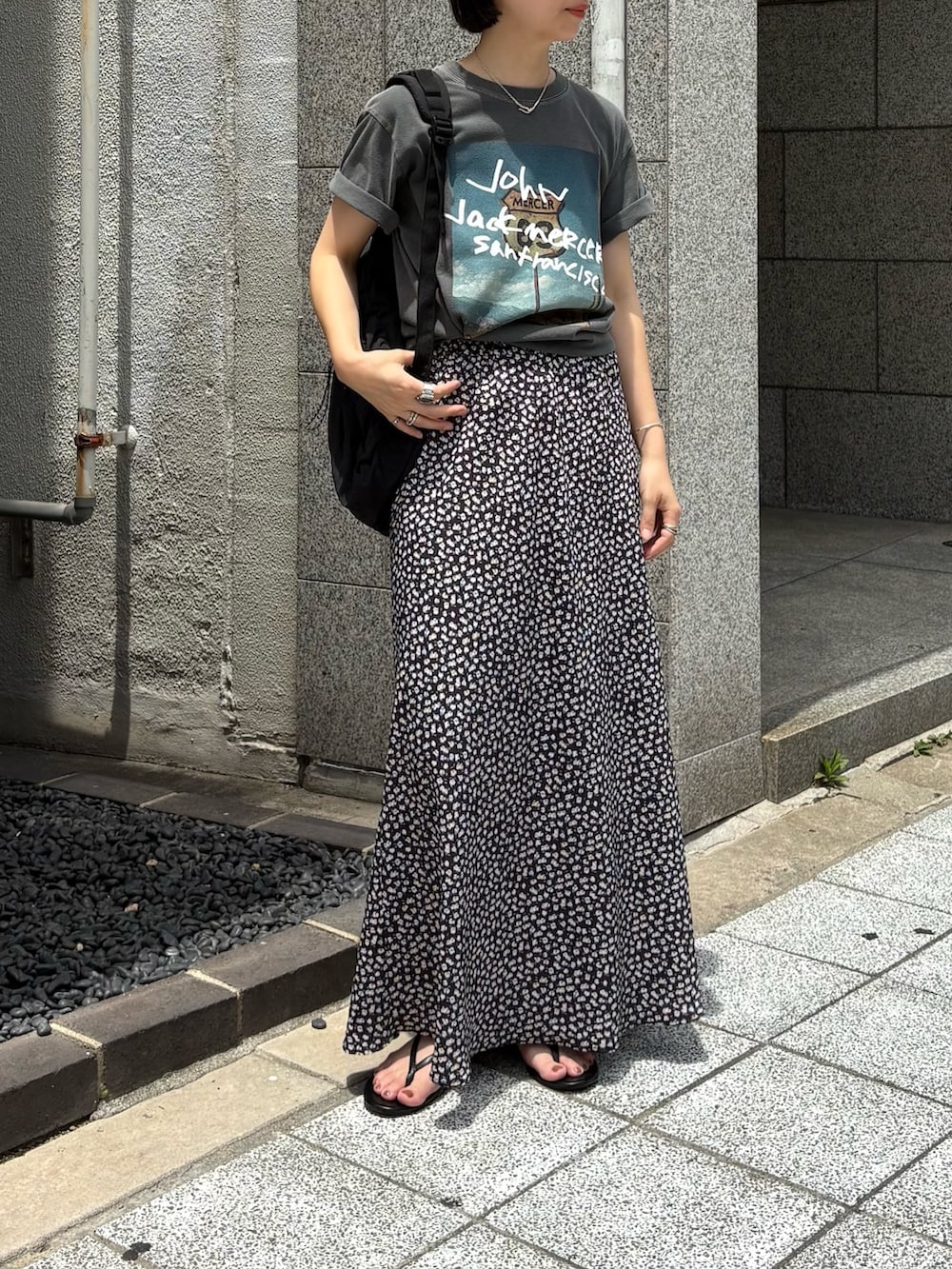 グレー系のTシャツ/カットソー、ホワイト系のスカート、ブラック系のバックパック/リュックを着用したレディースの夏コーディネートの2枚目の写真