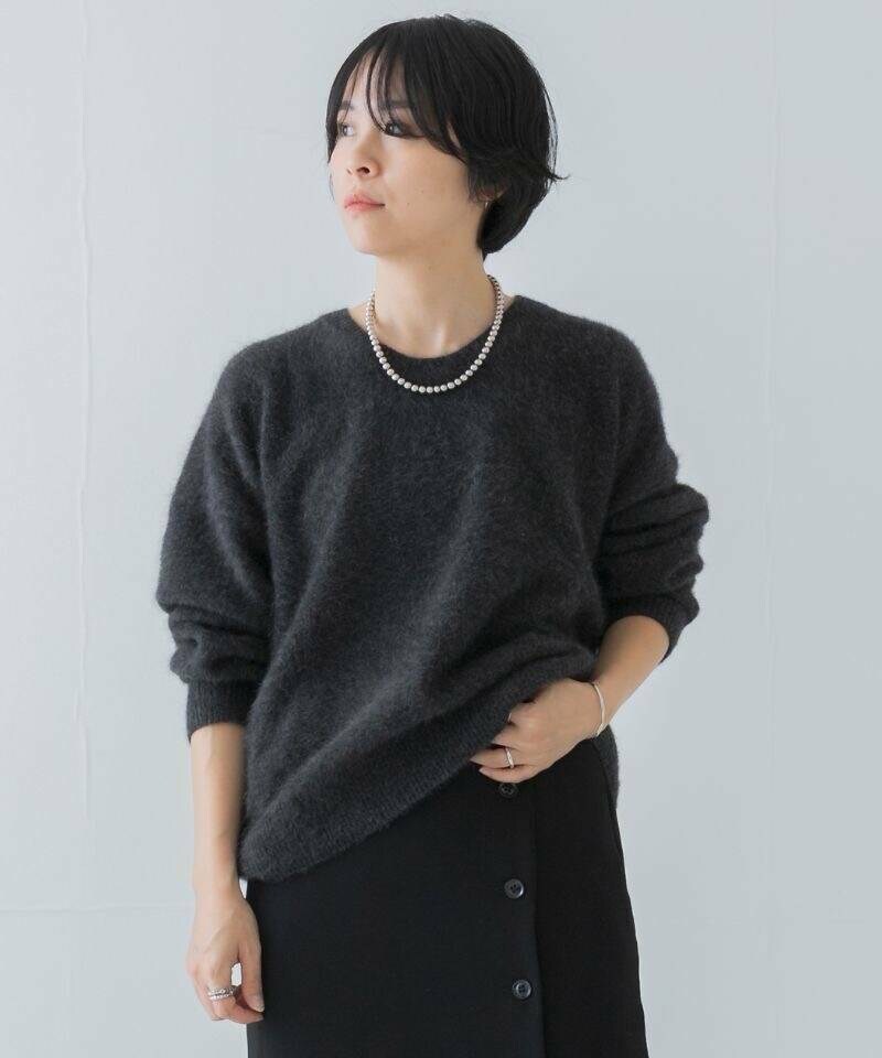 ブラック系のその他パンツ、ブラック系のスカート、グレー系のニット/セーターを着用したレディースの秋コーディネートの2枚目の写真