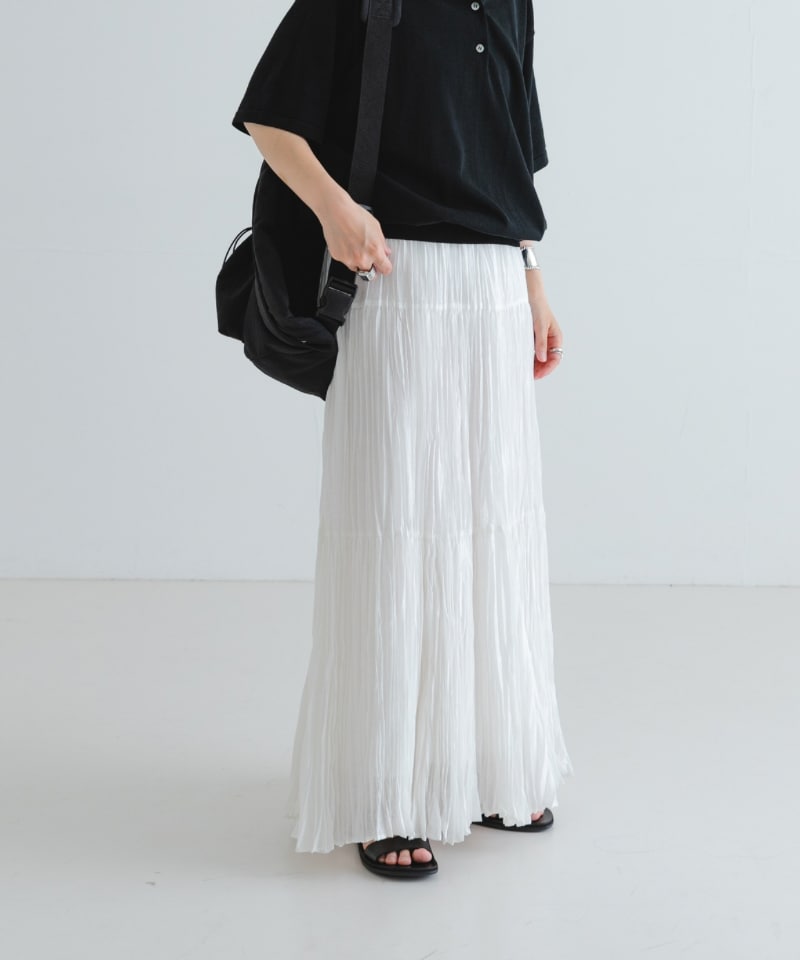 ブラック系のサンダル、ブラック系のバックパック/リュック、ホワイト系のスカートを着用したレディースの夏コーディネートの3枚目の写真