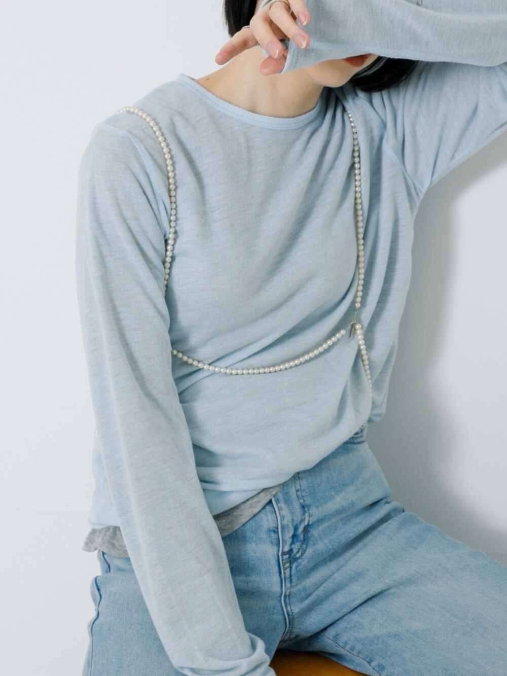 グレー系のTシャツ/カットソー、ブルー系のデニムパンツ、その他のネックレスを着用したレディースの春コーディネートの3枚目の写真