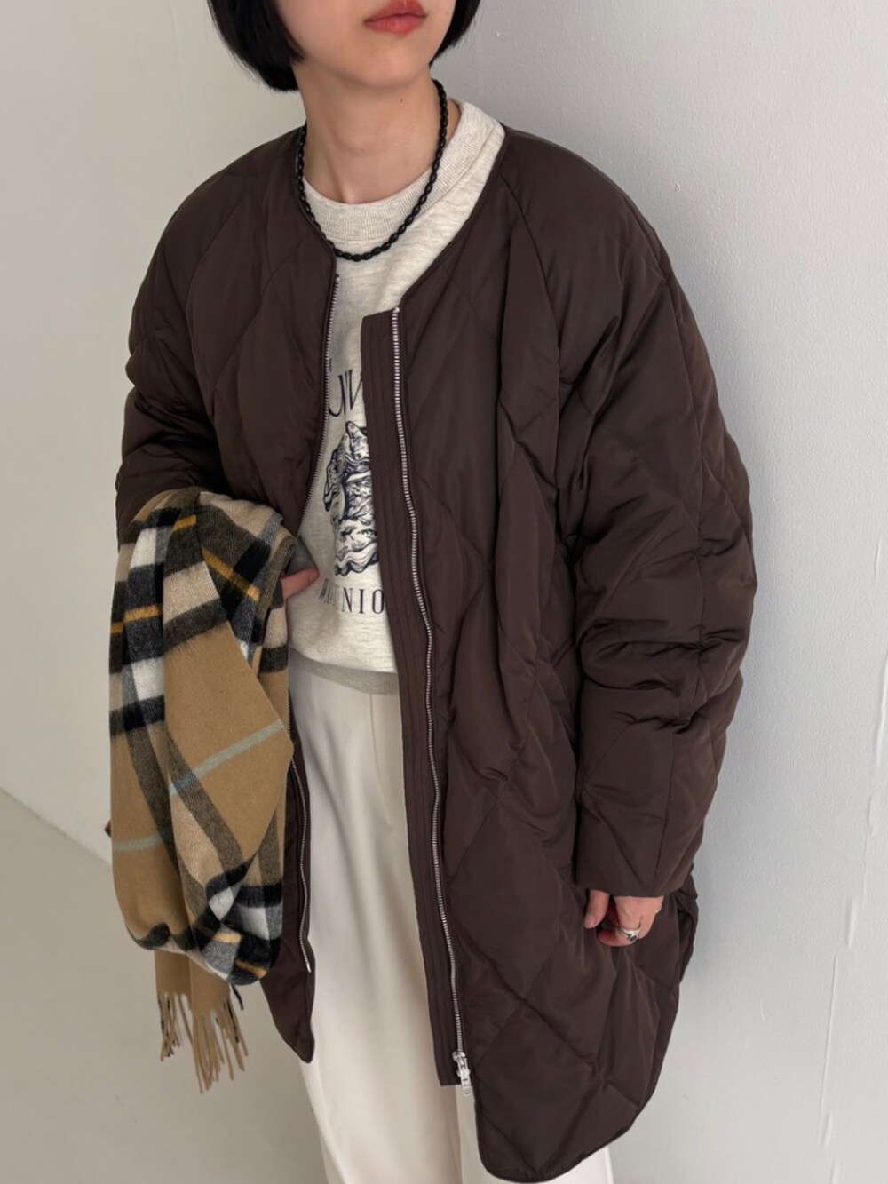 ベージュ系のスニーカー、ホワイト系のその他パンツ、ブラウン系のダウンジャケット/コートを着用したレディースの秋コーディネートの4枚目の写真