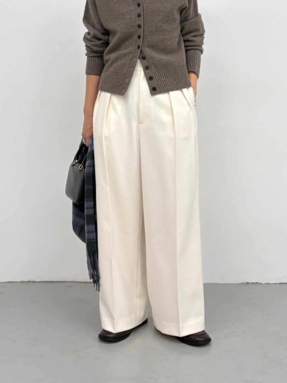 ブラウン系のカーディガン/ボレロ、ホワイト系のその他パンツ、ブラック系のショルダーバッグを着用したレディースの秋コーディネートの3枚目の写真