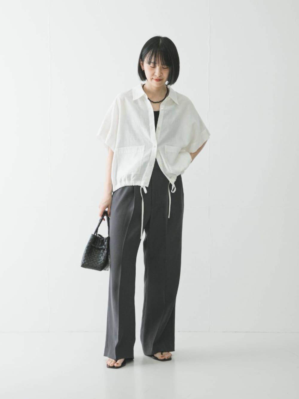 グレー系のその他パンツ、ブラック系のサンダル、ホワイト系のシャツ/ブラウスを着用したレディースの春コーディネートの2枚目の写真